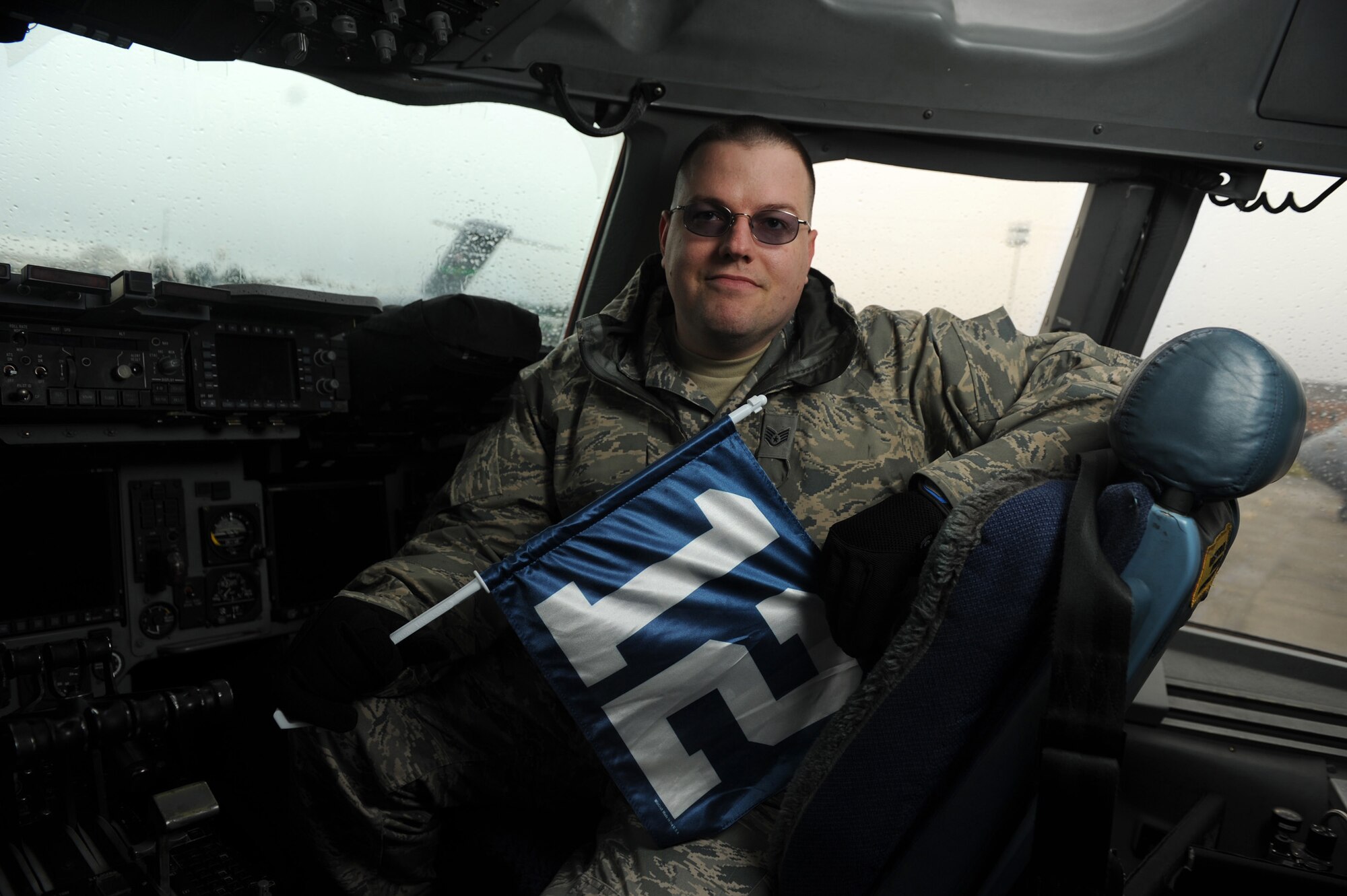 U.S. Air Force Staff Sgt. Joshua Mason of the 446th Aircraft Maintenance Squadron out of McChord Field, Wash., takes a moment to display the Seattle Seahawks' 12th Man flag to show 446th Airlift Wing appreciation for the Seahawks' support of military members around the world, Feb. 28, 2011. The Seahawks' website, www.spiritof12.com is dedicated to military members and Seahawks' fans. (U.S. Air Force photo by Staff Sgt. Chad Trujillo/Released)