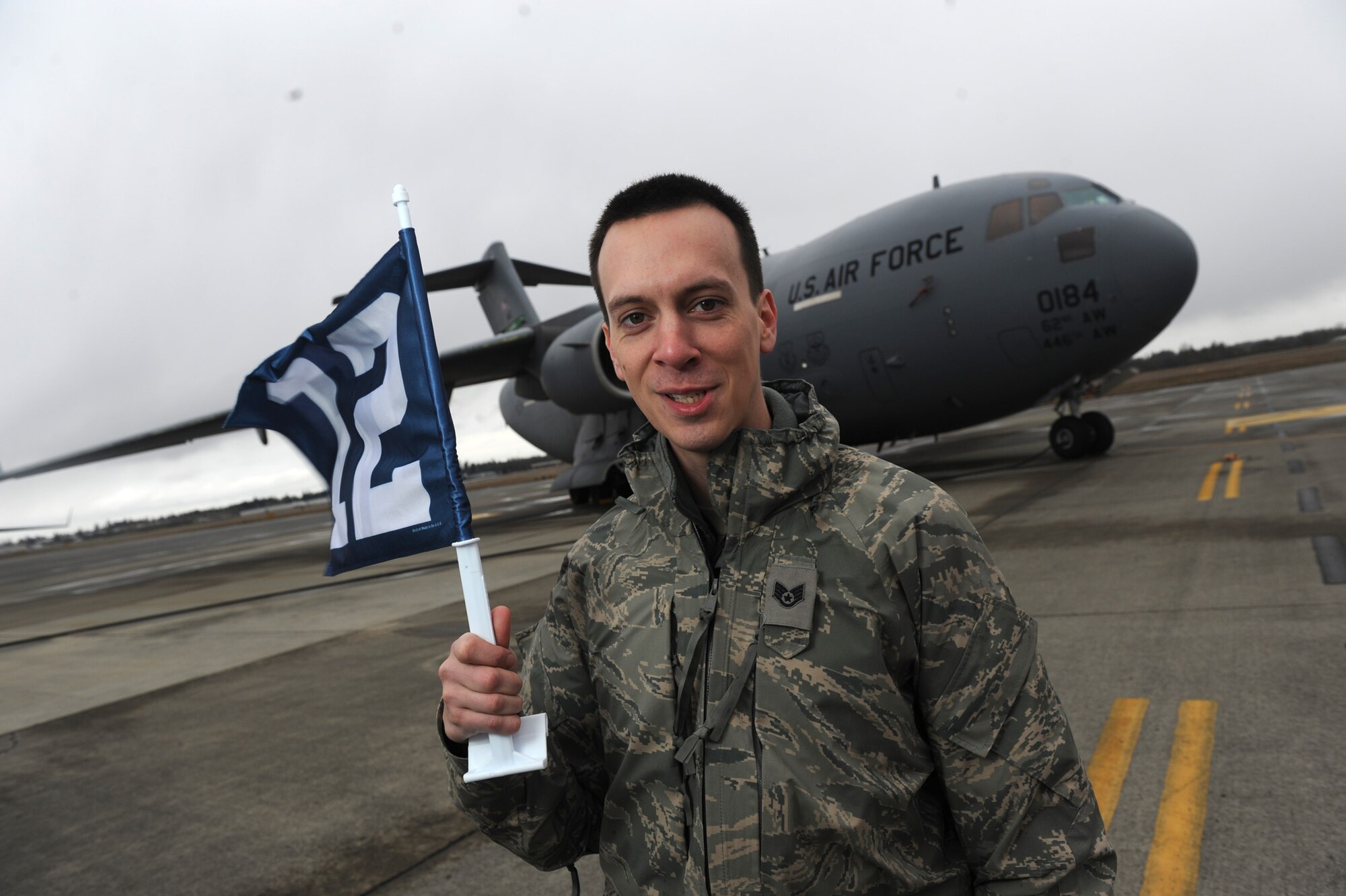 U.S. Air Force Staff Sgt. Darryl Castellano of the 446th Aircraft Maintenance Squadron out of McChord Field, Wash. takes a moment in raising the Seattle Seahawks' 12th Man flag to show 446th Airlift Wing appreciation for the Seahawks' support of military members, Feb. 28, 2011. The Seahawks' website, www.spiritof12.com is dedicated to military members and Seahawks fans around the world. (U.S. Air Force photo by Staff Sgt. Chad Trujillo/Released) 
