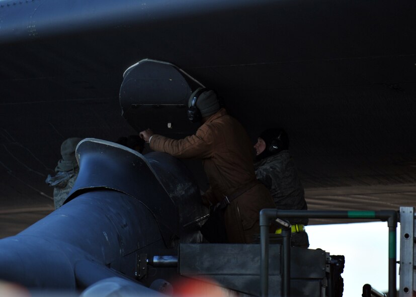 MINOT AIR FORCE BASE, N.D. -- Airmen from the 5th Munitions Squadron work underneath the wing of a B-52H Stratofortress during the recent operational readiness exercise, here Feb. 28.  Exercises like these are conducted to ensure Team Minot operates in a safe, secure, and reliable manner. (U.S. Air Force photo/Staff Sgt. Keith Ballard)