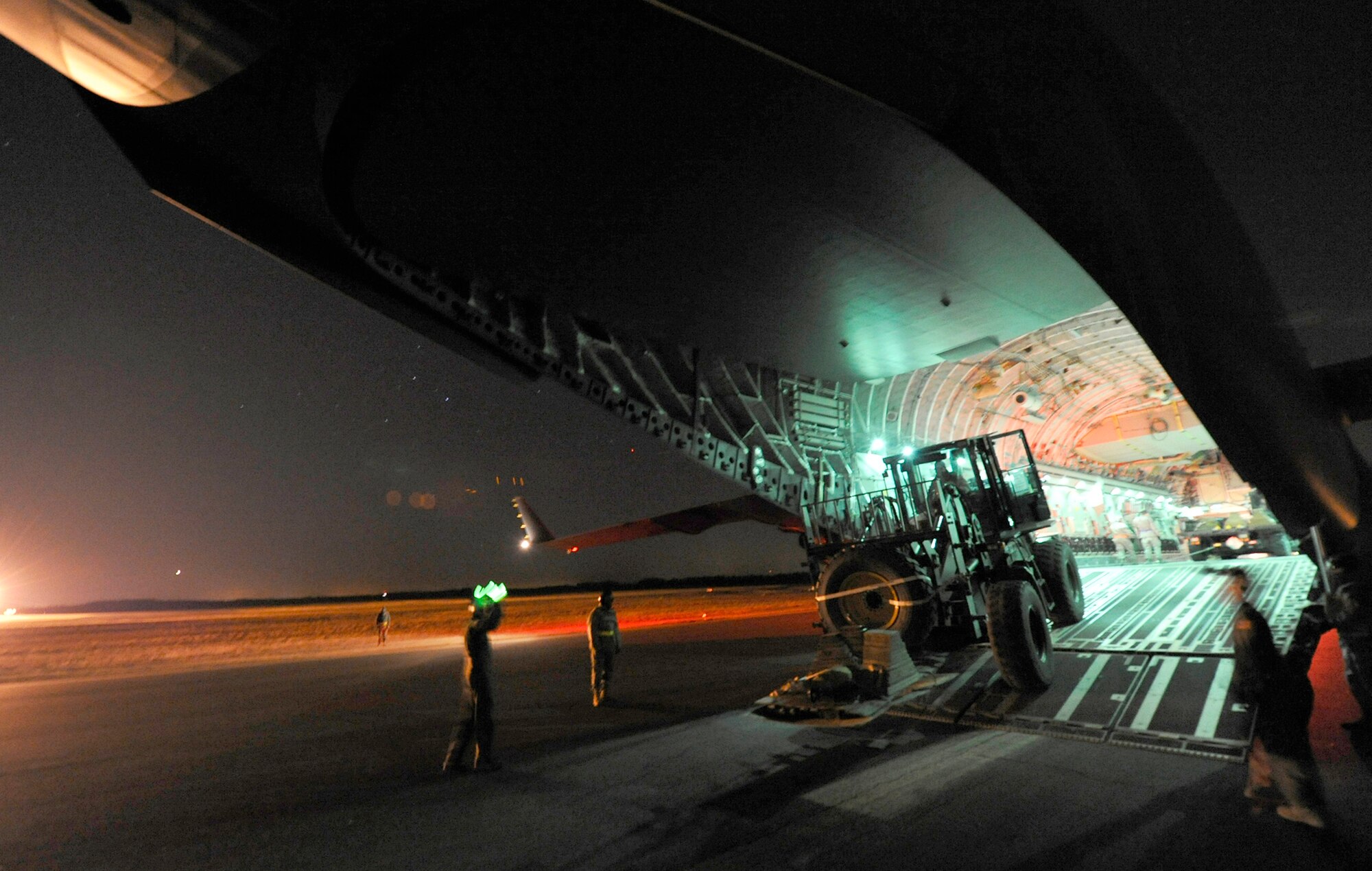 An aerial porter from the 621st Contingency Response Wing drives an articulated forklift from a C-17 Globemaster III during a nighttime engine-running offload Feb. 23, 2011, at Joint Base McGuire-Dix-Lakehurst, N.J. (U.S. Air Force photo/Tech. Sgt. Parker Gyokeres)