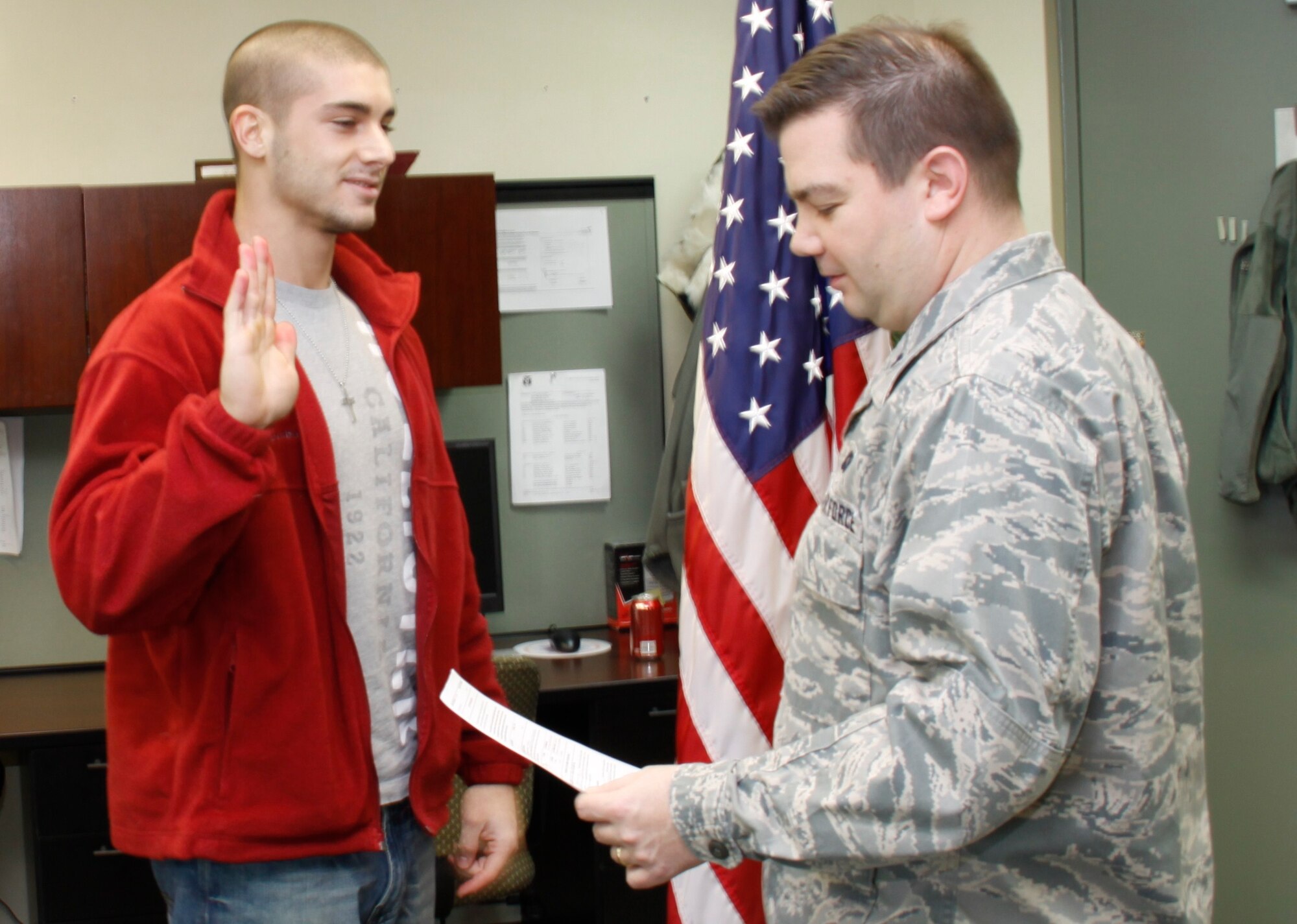 Aaron Simon is sworn in by 1st Lt. Shawn M. Walleck, 911th Airlift Wing chief of public affairs, during an enlistment ceremony Feb. 25. The newest Reservist will be a senior airman assigned to Security Forces. He currently attends the University of Pittsburgh at Greensburg and is a criminal justice major.(U.S. Air Force photo by Tech Sgt. Scott Pryor)