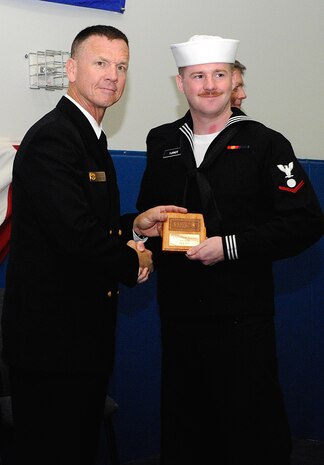Electrician’s Mate 3rd Class Paul Turner receives a class honorman plaque, awarded to the highest grade-point-average for the enlisted class of 1006, from keynote speaker Command Master Chief Jerry Pittman, Naval Recruiting District Phoenix, Ariz. during the Nuclear Power Schools graduation ceremony at Joint Base Charleston-Weapons Station, Feb. 25. (U.S. Navy photo/Machinist's Mate 3rd Class Brannon Deugan)