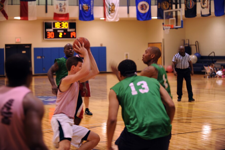 MOODY AIR FORCE BASE, Ga. -- Anthony Darby, 23rd Medical Group team member, attempts to out maneuver a team member of the 23rd Operations Support Squadron during an intramural basketball game Mar. 1. The 23rd MDG led the entire game due to good ball movement and playing as a team. (U.S. Air Force photo/Airman 1st Class Douglas Ellis)(RELEASED)
