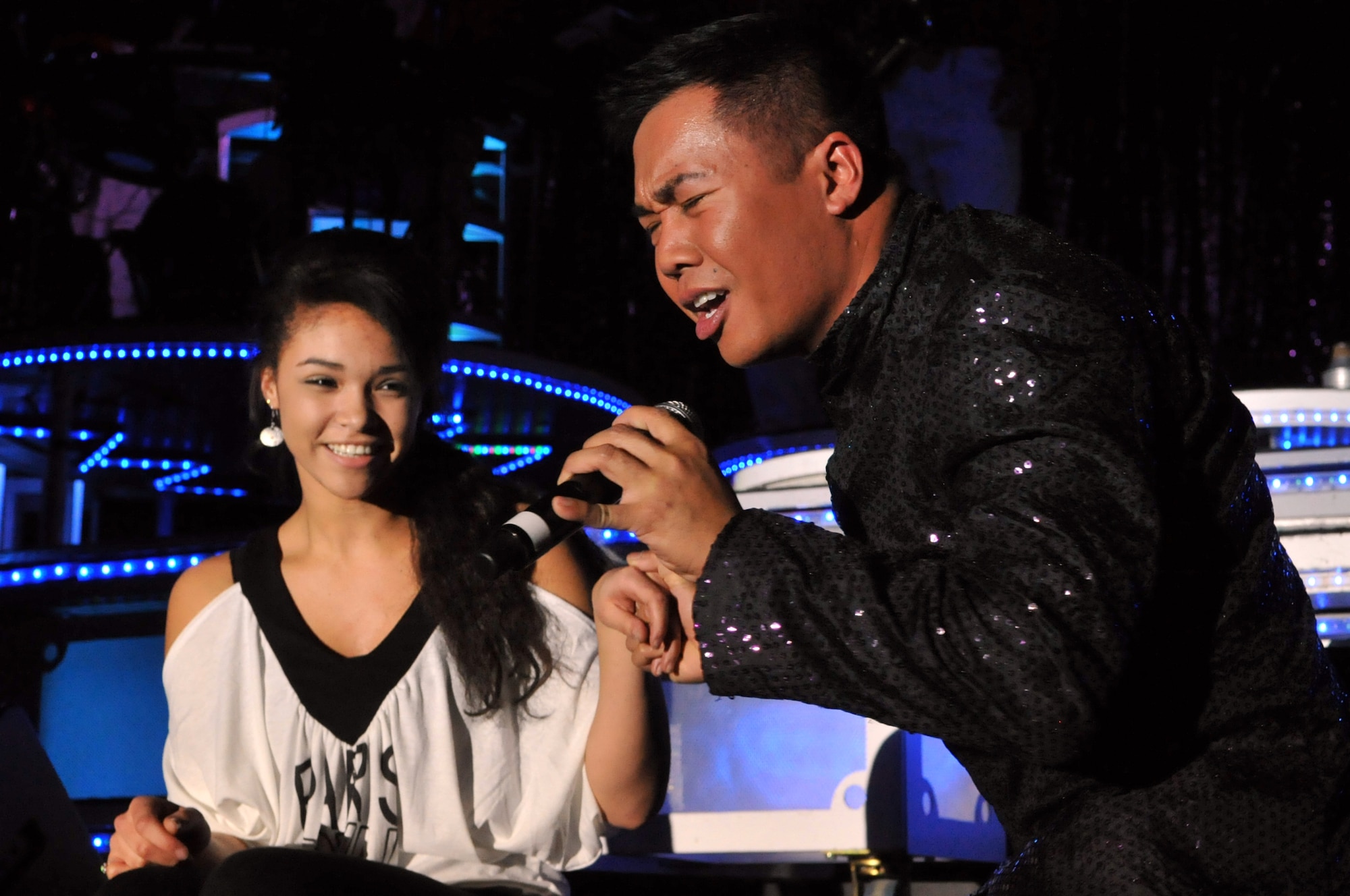 MINOT, N.D. – Staff Sgt. Harron Elloso, Tops in Blue vocalist, serenades a member of the audience during a Tops in Blue performance at the State Fair Grounds here Feb. 23. Tops in Blue serves as an expeditionary entertainment unit to provide quality entertainment from within Air Force resources for the Air Force family and personnel. (U.S. Air Force photo/Airman 1st Class Jessica McConnell)
