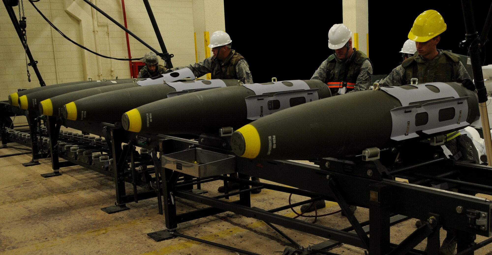 Staff Sgt. Matthew Owen, the18th Munitions Squadron munition systems craftsman, guides Mark 83 bomb bodies into a harness during Beverly High 11-03, a local operational readiness exercise, at Kadena Air Base, Japan, March 3. Kadena Airmen use LOREs to prepare for future contingencies. (U.S. Air Force photo/Airman 1st Class Jarvie Z. Wallace)