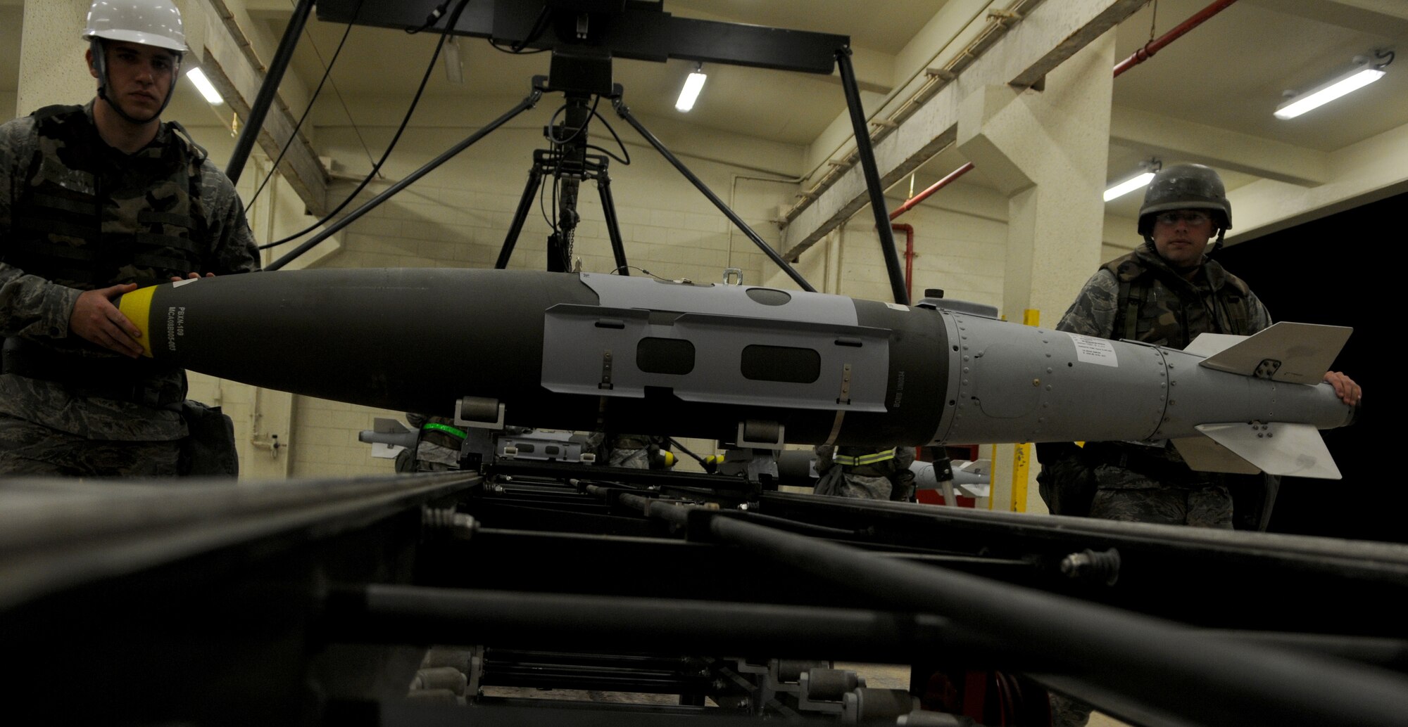 Airman 1st Class Greg  McDaniel and Senior Airman Denver Brandon, both 18th Munitions Squadron Tactical Air Rapid Response Packages (TARRP) crew members, place Mark 83 bomb bodies on a munitions assembly conveyer during Beverly High 11-03, a local operational readiness exercise, on Kadena Air Base, Japan, March 3. The 18th Wing is participating in the LORE to test the readiness of Kadena Airmen during various attack scenarios. (U.S. Air Force photo/ Airman 1st Class Jarvie Z. Wallace)