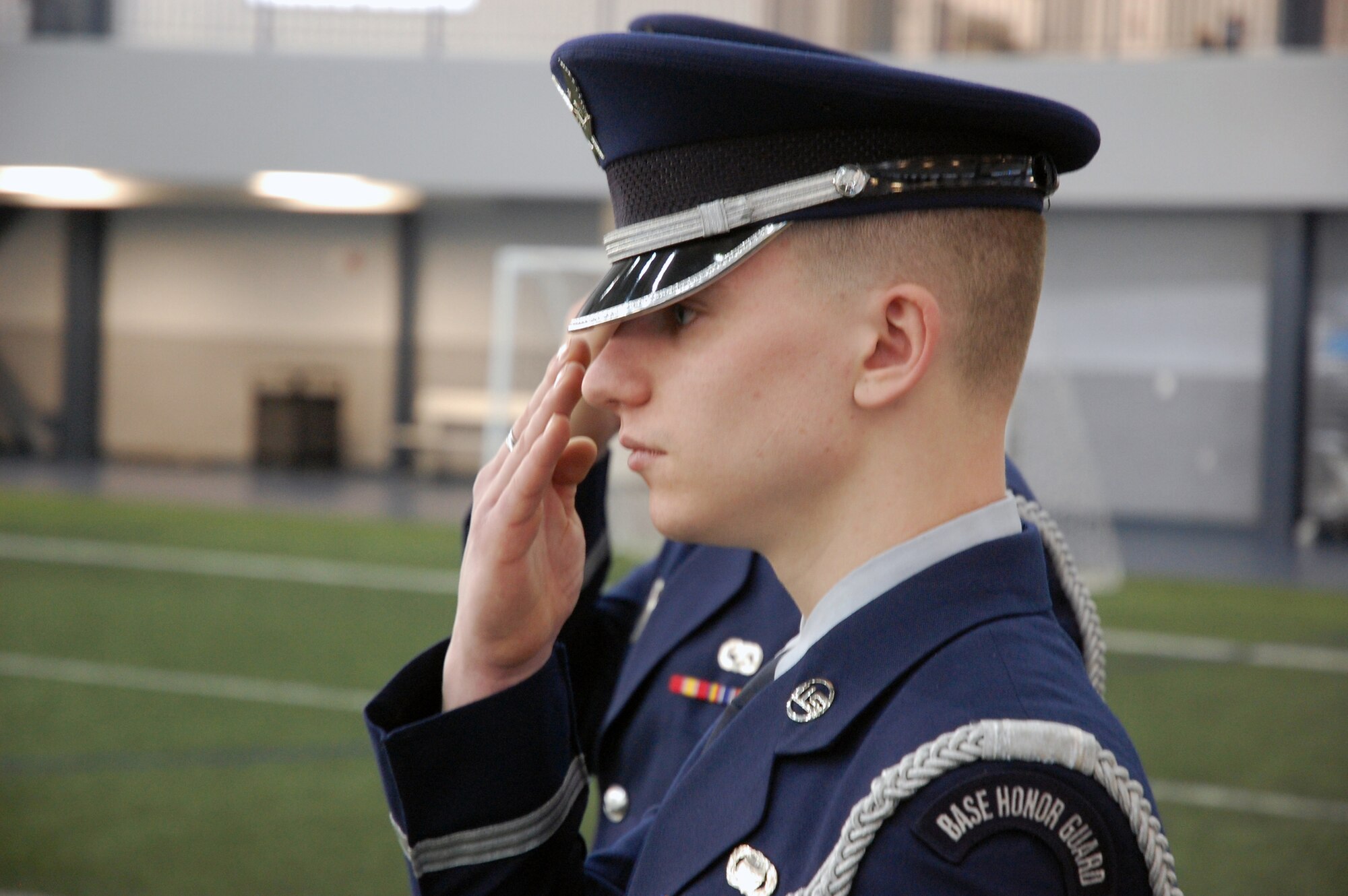 Airman 1st Class Nicholas Komor salutes as another honor guard member plays Taps at a mock funeral ceremony during the Eielson Air Force Base Honor Guard graduation Feb. 28, 2011. Airman Komor is assigned to the 354th Force Support Squadron. (U.S. Air Force photo/Tech. Sgt. Shad Eidson)