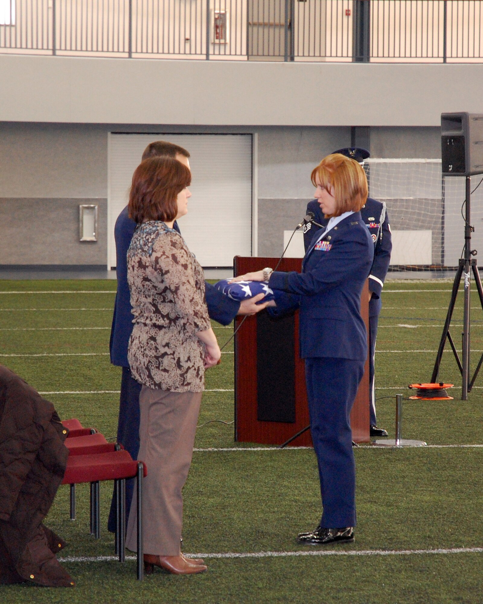 Capt. Heather Hodgson presents a folded flag as part of a mock funeral ceremony during the Eielson Air Force Base Honor Guard graduation Feb. 28, 2011. Captain Hodgson is assigned to the 354th Force Support Squadron. (U.S. Air Force photo/Tech. Sgt. Shad Eidson)