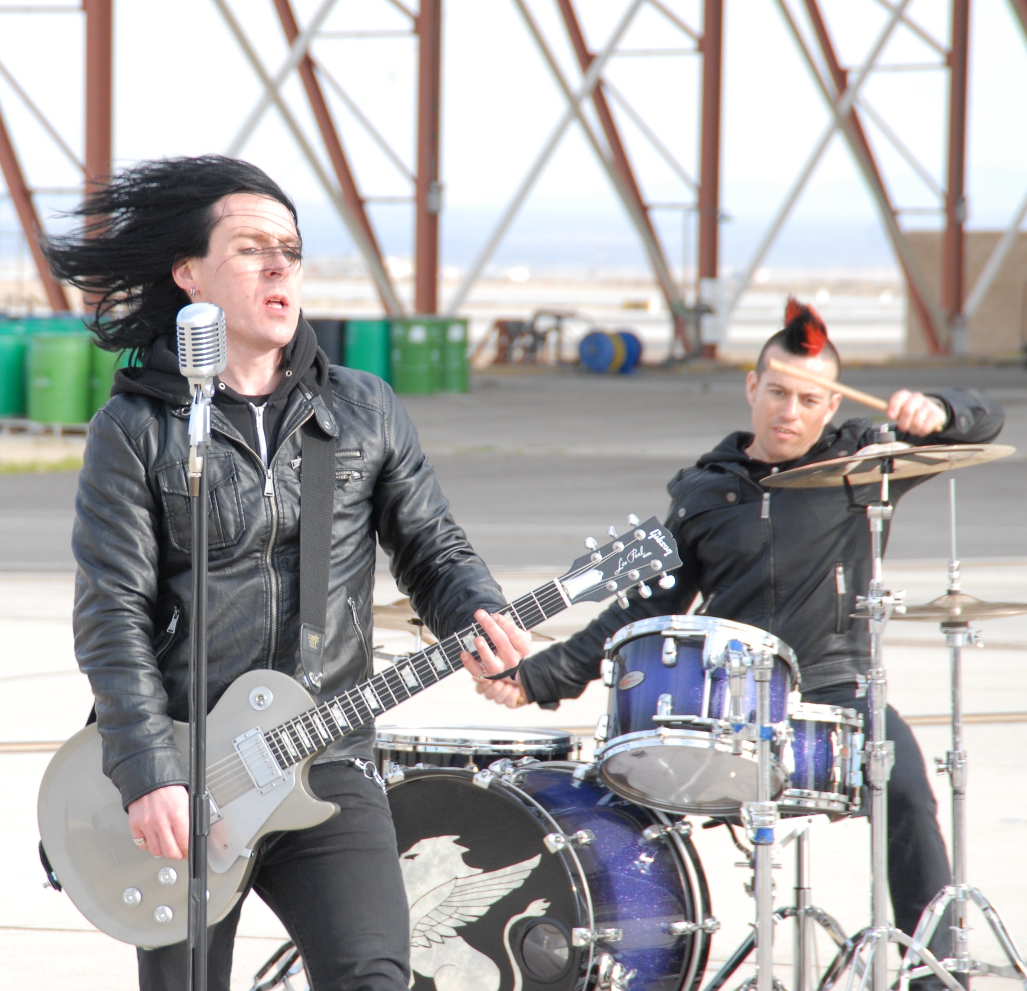 Melotia band members Ryan David (foreground) and drummer Clark Skelton perform their new single “We are the Chosen” in front of the wash rack near Hangar 1600 at Edwards Feb. 23. The Los Angeles-based hard rock band requested to come out and film a music video here because of the song’s nature and the base’s military backdrop. (Air Force photo by Kenji Thuloweit)