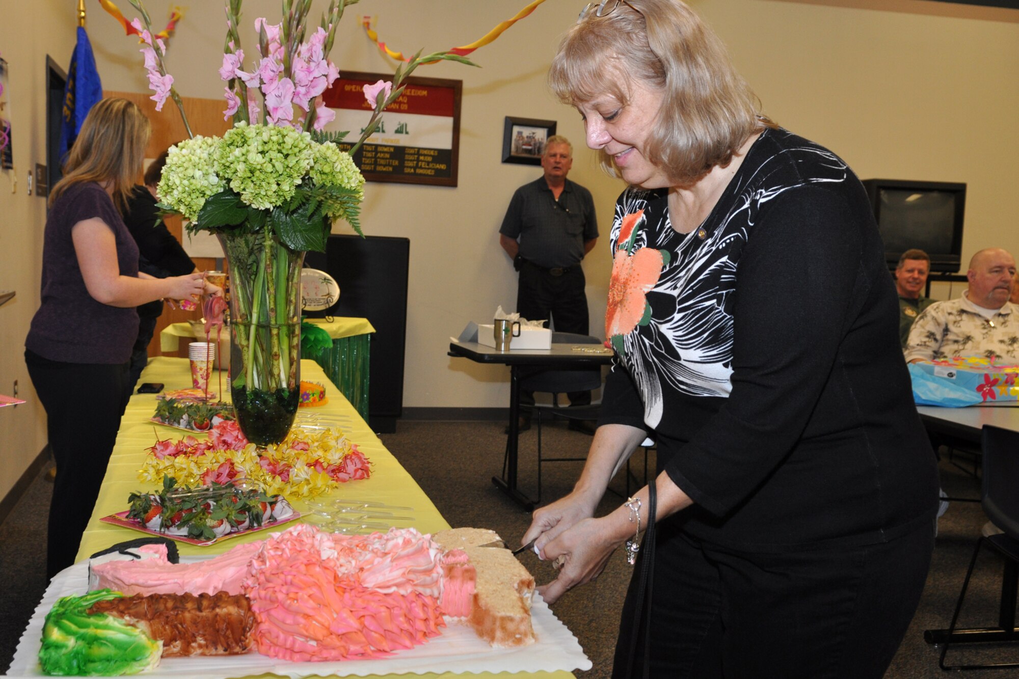 Carole Little, a budget analyst for the 307th Bomb Wing, cuts a pink flamingo cake during a cake and punch social celebrating her retirement at Barksdale Air Force Base, La., Feb. 24, 2011. Ms. Little, who started her career in the Regular Air Force, is retiring after 34 years of faithful service to her country. She is originally from Pennsylvania, and will be relocating to Florida with her husband John to enjoy her retirement years. (U.S. Air Force photo/ Tech. Sgt. Jeff Walston) 