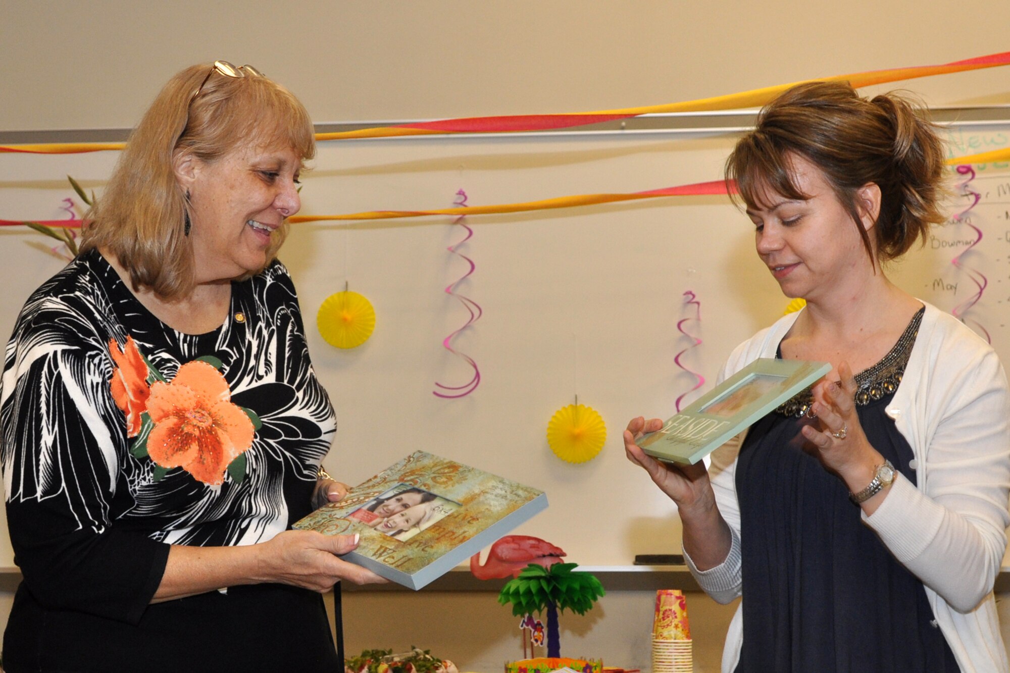 Carole Little, a budget analyst for the 307th Bomb Wing, receives a gift from her co-worker Rachelle Wood, budget assistant, 307th BW, during a cake and punch social celebrating her retirement at Barksdale Air Force Base, La., Feb. 24, 2011. Ms. Little, who started her career in the Regular Air Force, is retiring after 34 years of faithful service to her country. She is originally from Pennsylvania, and will be relocating to Florida with her husband John to enjoy her retirement years. (U.S. Air Force photo/ Tech. Sgt. Jeff Walston) 