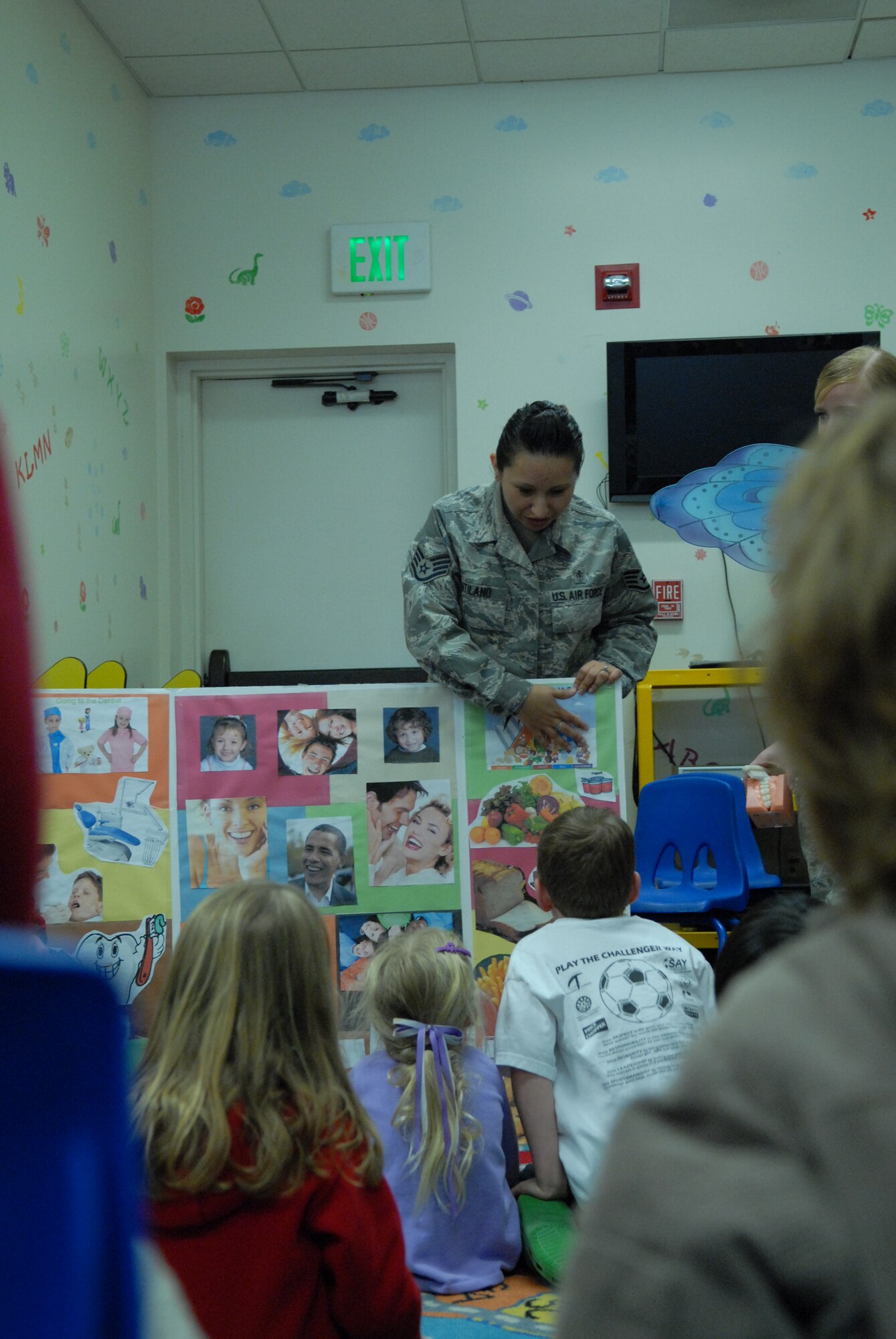 Staff Sgt. Cynthia Atilano, 95th Medical Group certified dental assistant, holds a captive group of Little Hands Pre-School students as she explains the importance of establishing good dental habits. The 95th MDG dental office helped promote the American Dental Association’s National Children’s Dental Health Month in the Children’s Library Feb. 23 and Feb. 25. (Air Force photo by Kate Blais)