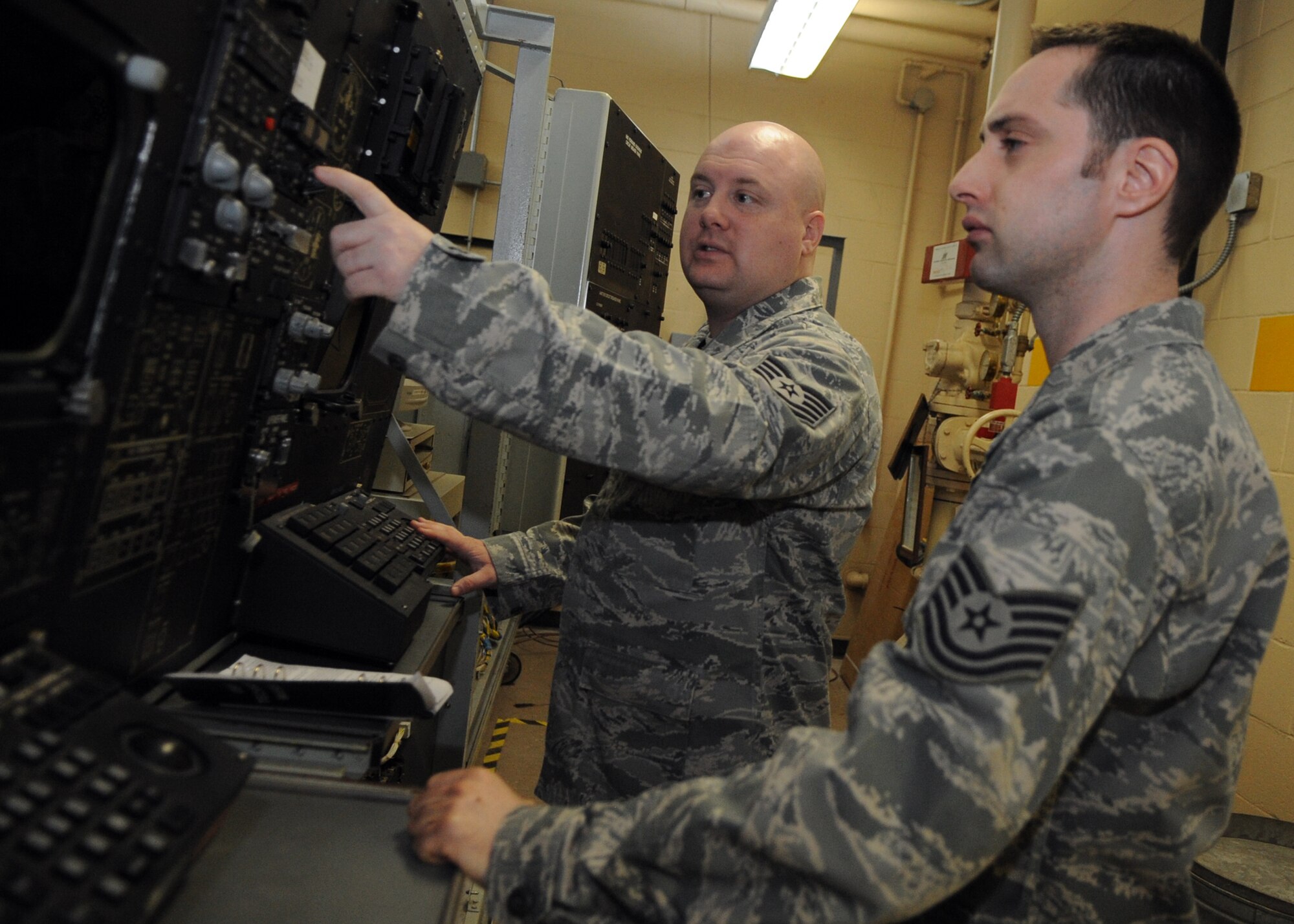 MINOT AIR FORCE BASE, N.D. -- Tech. Sgt. Charles Waters, 372nd Training Squadron B-52 communication and navigation mission systems instructor ensures Tech. Sgt. Shane Sawyer, 5th Maintenance Squadron crew chief, gains familiarization of navigation components. Craft familiarization is essential for cross-over maintainers who have not yet had a chance to work on bomber aircraft specific to this base. (U.S. Air Force photo/Airman 1st Class Jose L. Hernandez)