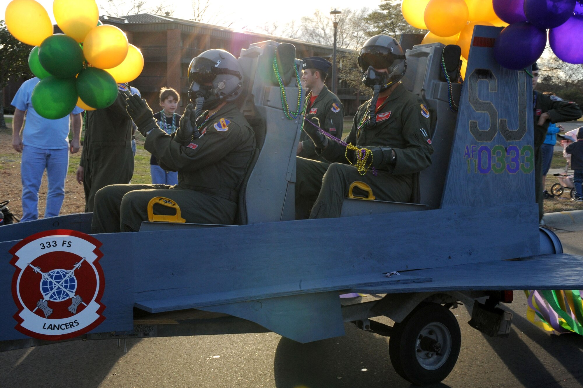 SEYMOUR JOHNSON AIR FORCE BASE, N.C. -- Aircrew members of 333rd Fighter Squadron soar through a Mardi Gras "Catch the Beads" parade, here Feb. 25, 2011. The Mardi Gras events began with a cajun chicken cook-off and ended with a masquerade party. (U.S. Air Force photo/Staff Sgt. Courtney Richardson) (RELEASED)