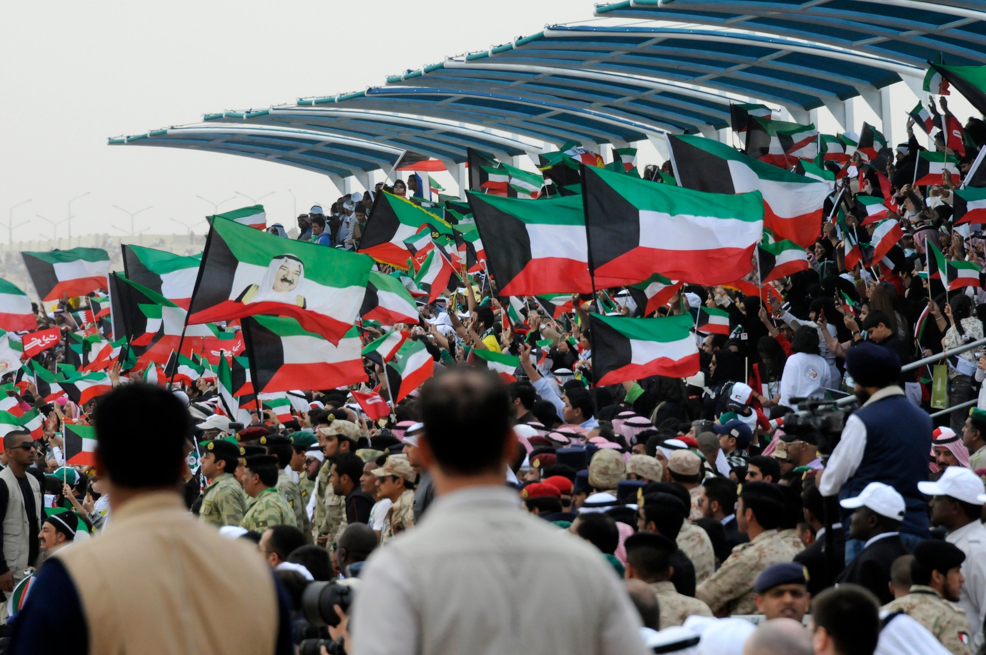 Citizens of Kuwait cheer during a parade to celebrate the nation's 50th anniversary of its liberation from Great Britain and 20th anniversary of its liberation from Iraq. (U.S. Air Force photo by Capt. Heath Allen)