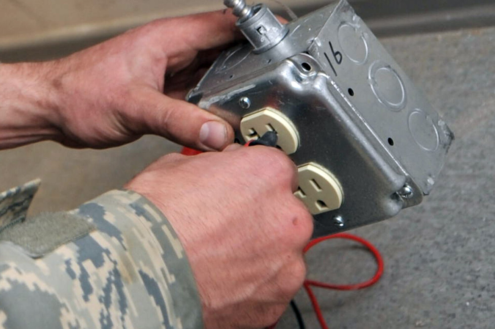 Staff Sgt. Ryan Sendrick, 455th Expeditionary Civil Engineer Squadron electrician, checks the voltage on the electrical receptacle outlet to ensure that it is working properly before installing specialty equipment at Bagram Airfield, Afghanistan, March 3, 2011. (Air Force photo by Senior Airman Sheila deVera)