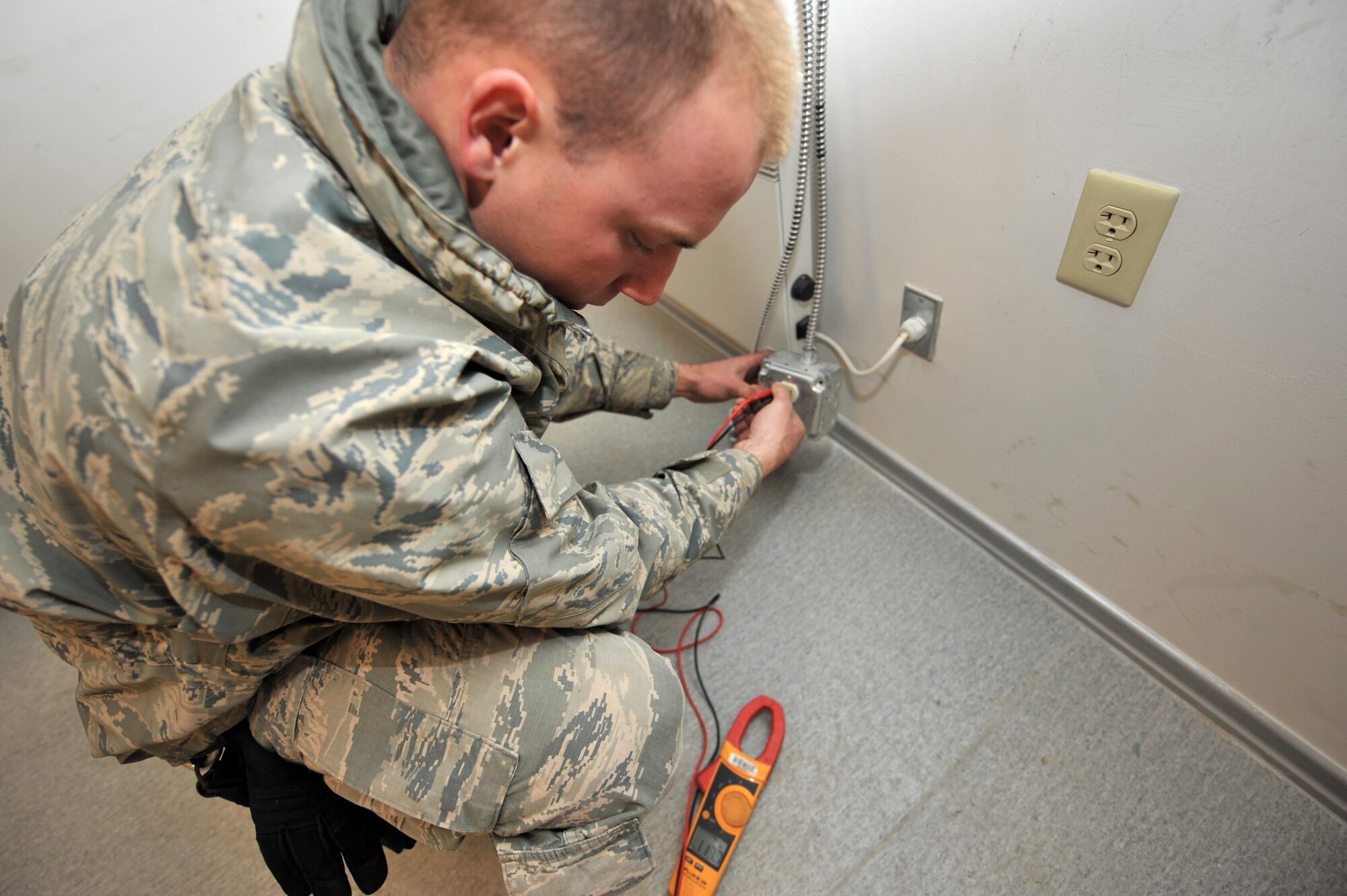 Staff Sgt. Ryan Sendrick, 455th Expeditionary Civil Engineer Squadron electrician, checks the voltage on the electrical receptacle outlet to ensure that it is working properly before installing specialty equipment at Bagram Airfield, Afghanistan, March 3, 2011. (Air Force photo by Senior Airman Sheila deVera)