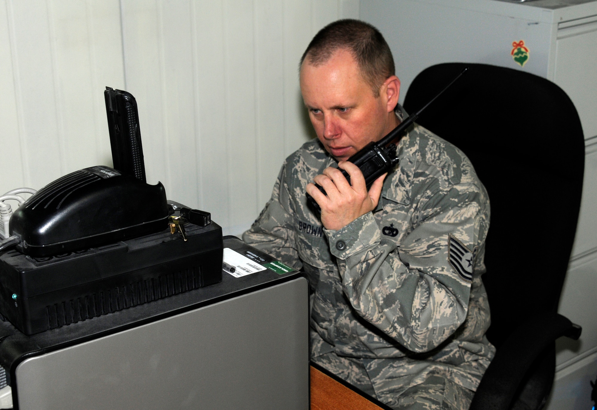 Technical Sgt. Ron Brown calls in a flight schedule change Feb. 27 at the 386th Air Expeditionary Wing. Sergeant Brown, who is an air transportation craftsman for the 386th, served in Operation Desert Storm as a B-52 Bomber weapons loader.  (U.S. Air Force photo by Capt. Heath Allen)
