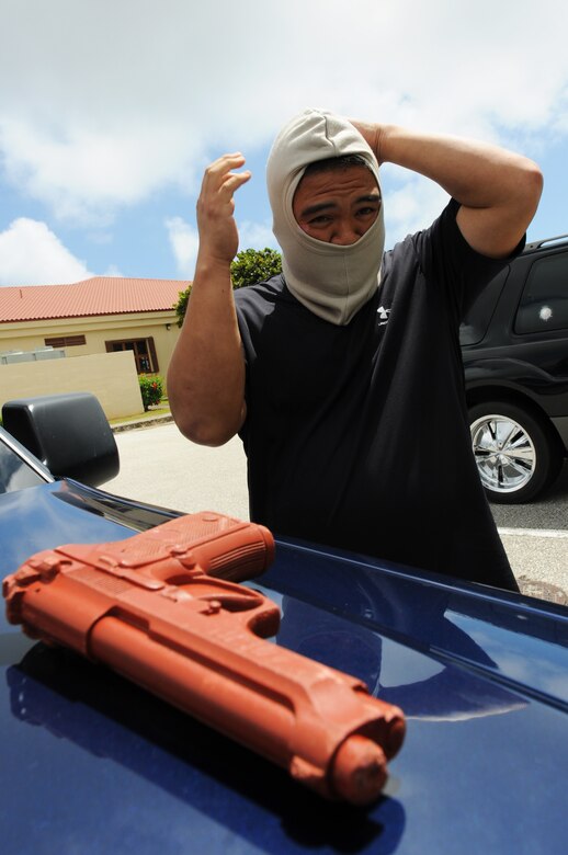 Staff Sgt. Michael Balmaceda, 736th Security Forces Squadron prepares to simulate a robbery at the 36th Comptroller Squadron March 1. The robbery was part of an Operational Readiness Exercise, evaluating security forces personnel’s response in the event of an armed robbery. (U.S. Air Force photo/Senior Airman Carlin Leslie)