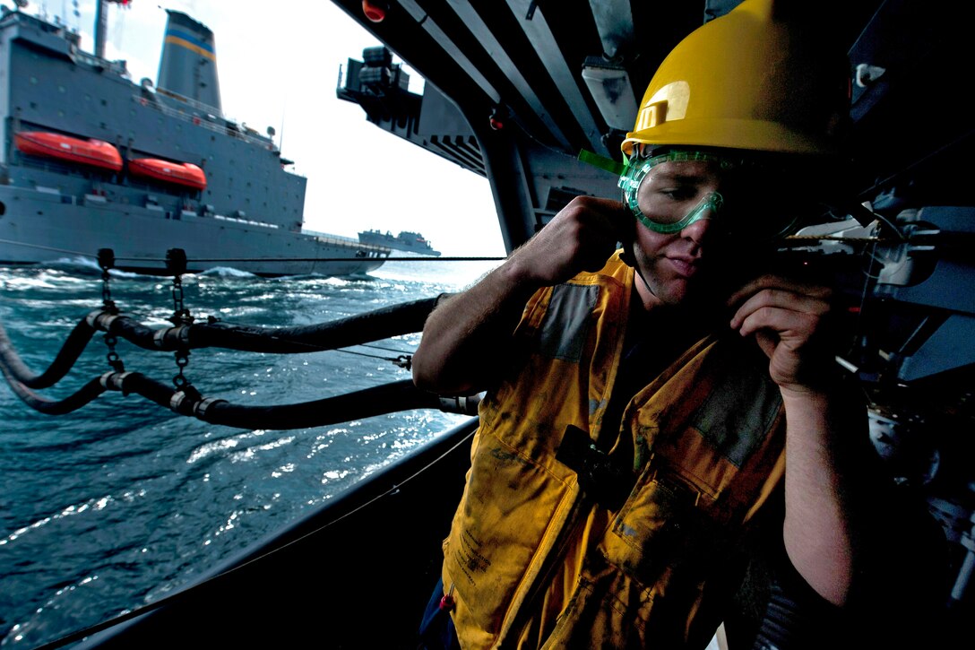 U.S. Navy Petty Officer 3rd Class Christopher Cook repeats orders in a fueling station aboard the Nimitz-class aircraft carrier USS Carl Vinson in the Arabian Sea, Feb. 25, 2011.