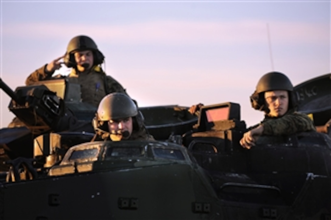 U.S. Marine Corps Cpl. Matthew Adams (left), a crew chief, driver Lance Cpl. Devon Ridgway and Pfc. Andrey Fortygin (right), with the 3rd Assault Amphibian Battalion, 1st Marine Division, land an amphibious assault vehicle on the beach at Camp Pendleton, Calif., during Exercise Iron Fist on Feb. 28, 2011.  Iron Fist is a three-week bilateral training event between the Marine Corps and Japan Ground Self-Defense Force designed to increase interoperability between the two services while aiding the Japanese in their continued development of amphibious capabilities.  