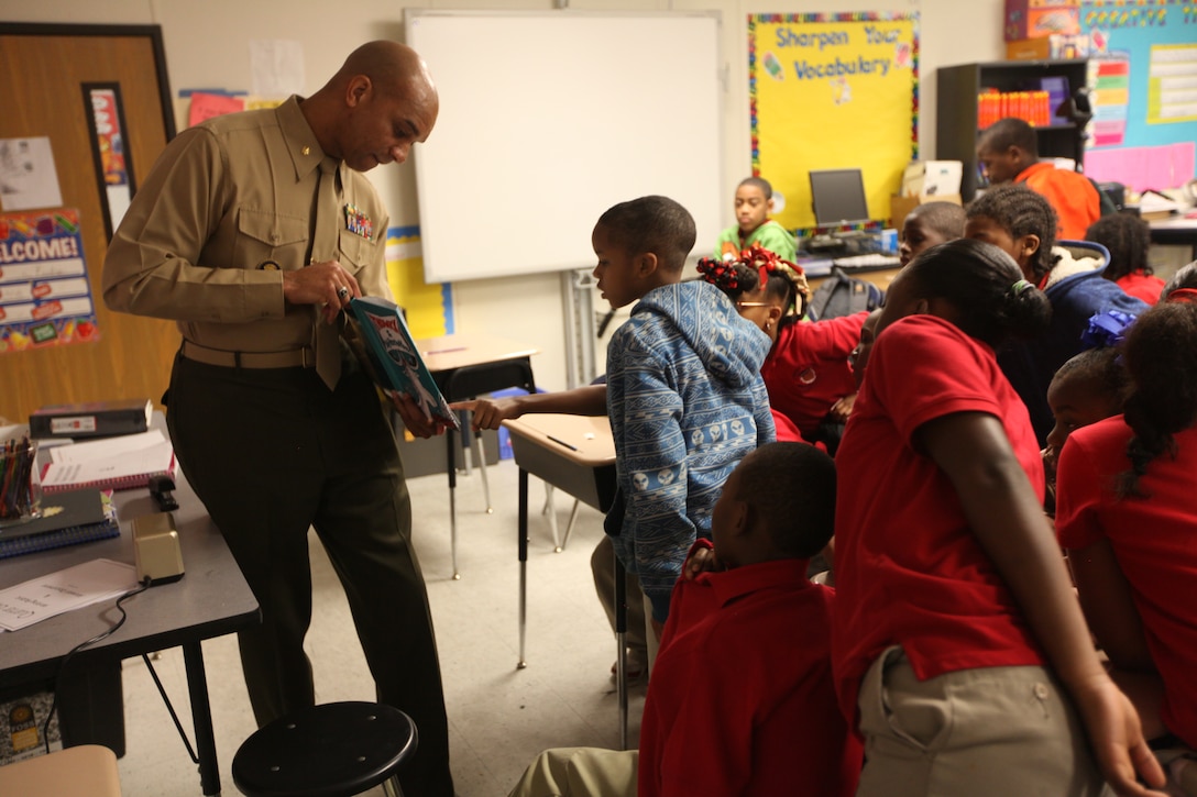Maj. Jason Davis, the 4th Marine Aircraft Wing avionics officer, shows the pictures in a Dr. Seuss book to students at Sarah T. Reed Elementary School March 2.  Davis was one of the Marines who volunteered to participate in the Dr. Seuss Day celebration.