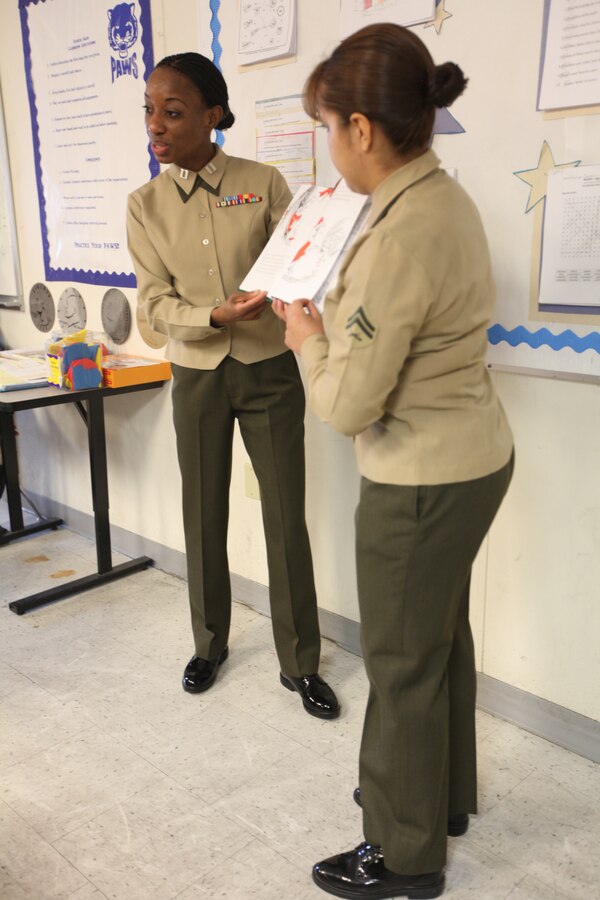 Capt. Tabitha White, the Marine Forces Reserve casualty assistance calls officer, and Cpl. Irene Perdomo, the distribution management office noncommissioned officer, read a Dr. Seuss book to students at Sarah T. Reed Elementary School March 2.