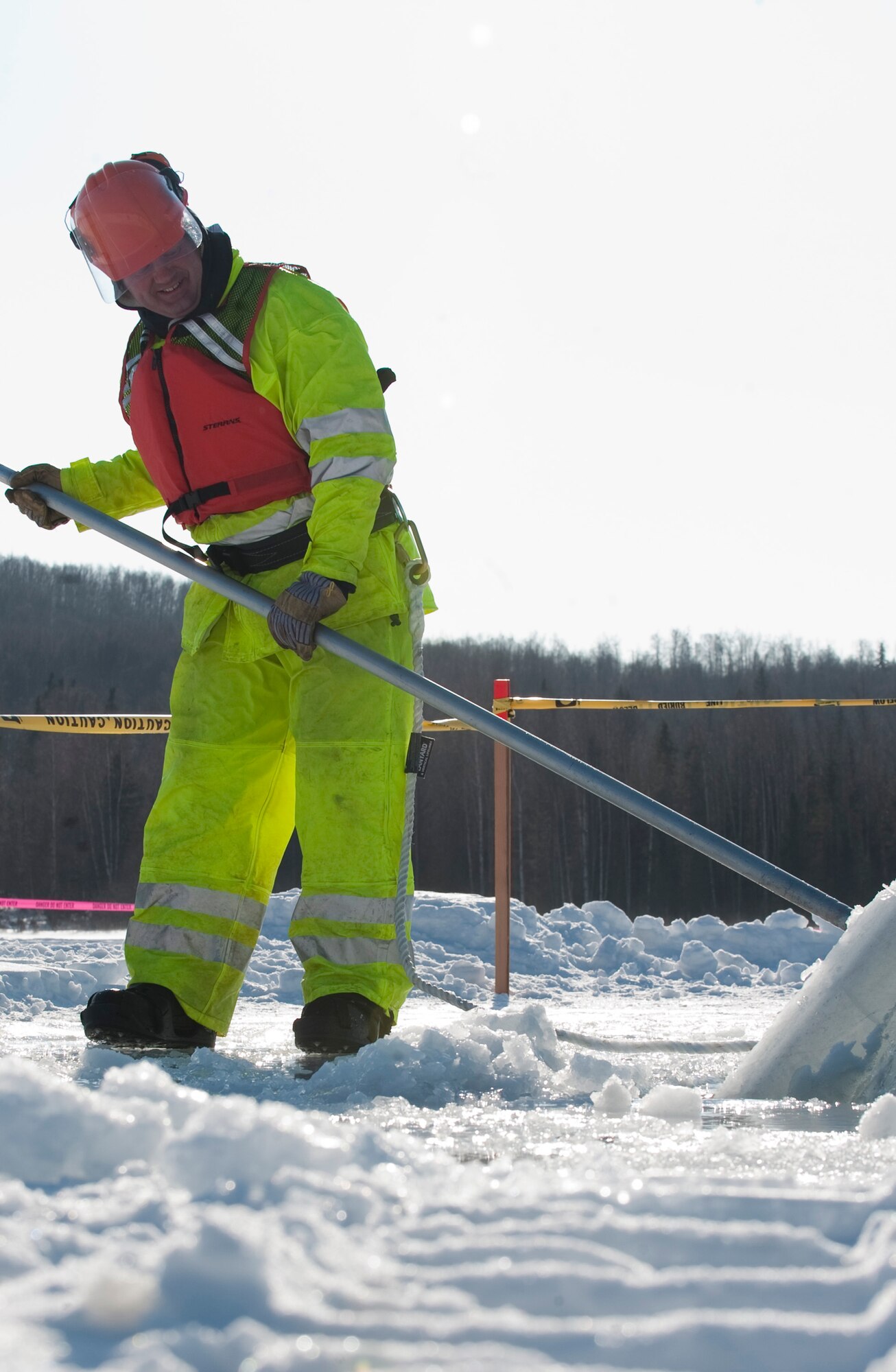 JOINT BASE ELMENDORF-RICHARDSON, Alaska -- Tech. Sgt. Andrew Perrin, 611th Civil Engineer Squadron, adjust a block of ice bobbing in the water March 1 at JBER's Six-Mile Lake during the annual Ice Operations Exercise. Approximately a combined 60 members from the 611th CES, U.S. Coast Guard, the Navy's Supervisor of Salvage, Alaska Department of Environmental Conservation and the Alaska Chadux Corporation participated in the annual exercise, where participants practice various oil spill clean-up drills in preparation if there was ever an event here in Alaska. (U.S. Air Force photo by Senior Airman Christopher Gross)