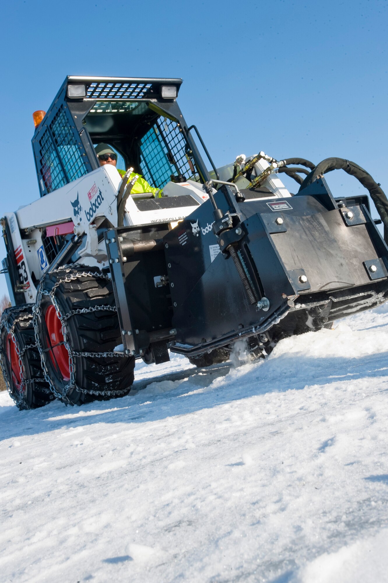 JOINT BASE ELMENDORF-RICHARDSON, Alaska -- Tech. Sgt. Eddie Campbell, 611th Civil Engineer Squadron, uses a Bobcat to carve a trench into the ice March 1 at JBER's Six-Mile Lake during the annual Ice Operations Exercise. Approximately a combined 60 members from the 611th CES, U.S. Coast Guard, the Navy's Supervisor of Salvage, Alaska Department of Environmental Conservation and the Alaska Chadux Corporation participated in the annual exercise, where participants practice various oil spill clean-up drills in preparation if there was ever an event here in Alaska. (U.S. Air Force photo by Senior Airman Christopher Gross)