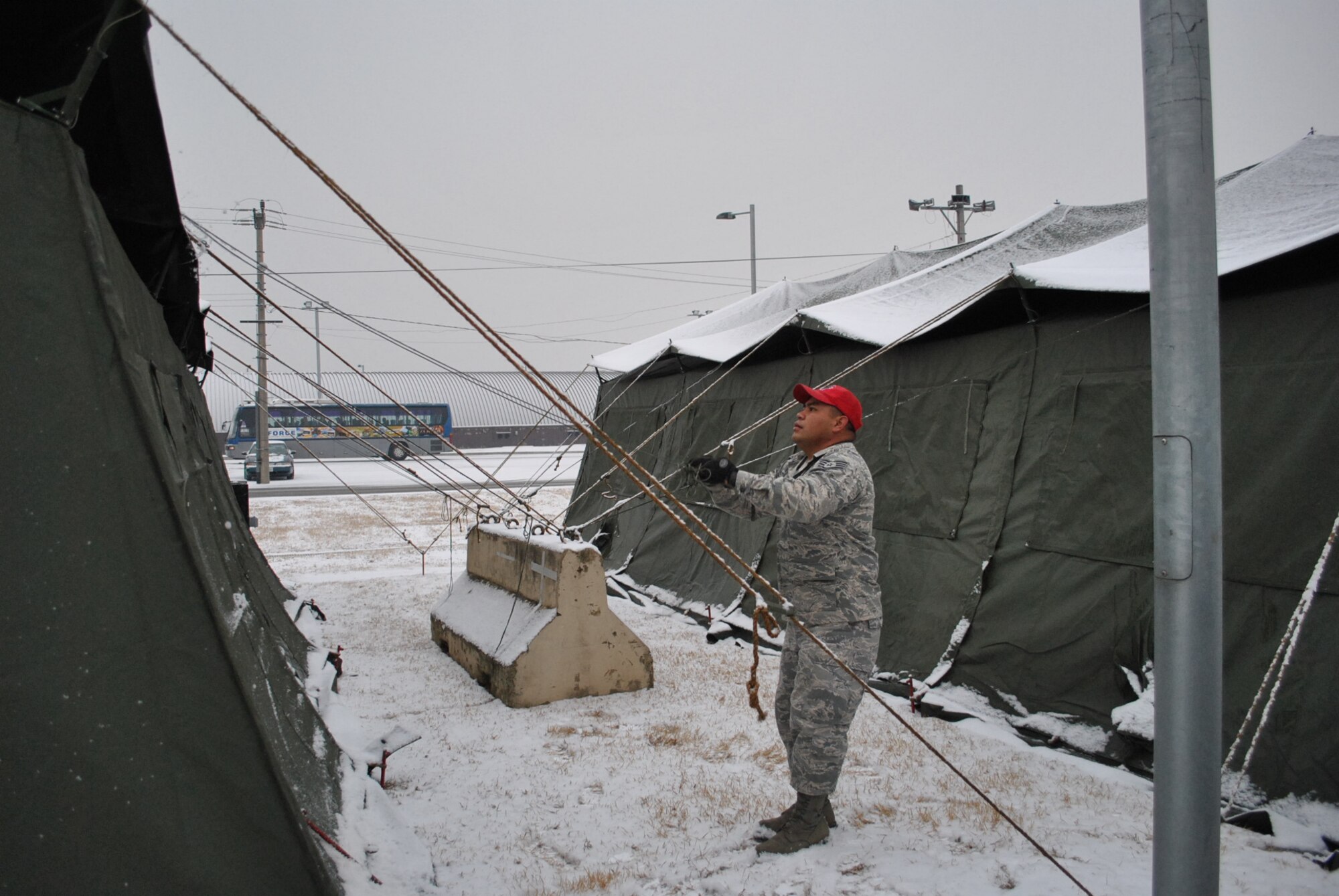A member of the 254th Rapid Engineer Deployable Heavy Operational Repair Squadron Engineers (RED HORSE), Guam Air National Guard, sets up tents Feb. 17, 2011, in Rush Park at Osan Air Base, Republic of Korea. Rush Park will house nearly 500 augmentees participating in Key Resolve, a ROK-U.S. command post exercise scheduled Feb. 28 to March 10, 2011. (U.S. Air Force photo courtesy of 254th Air Base Group)