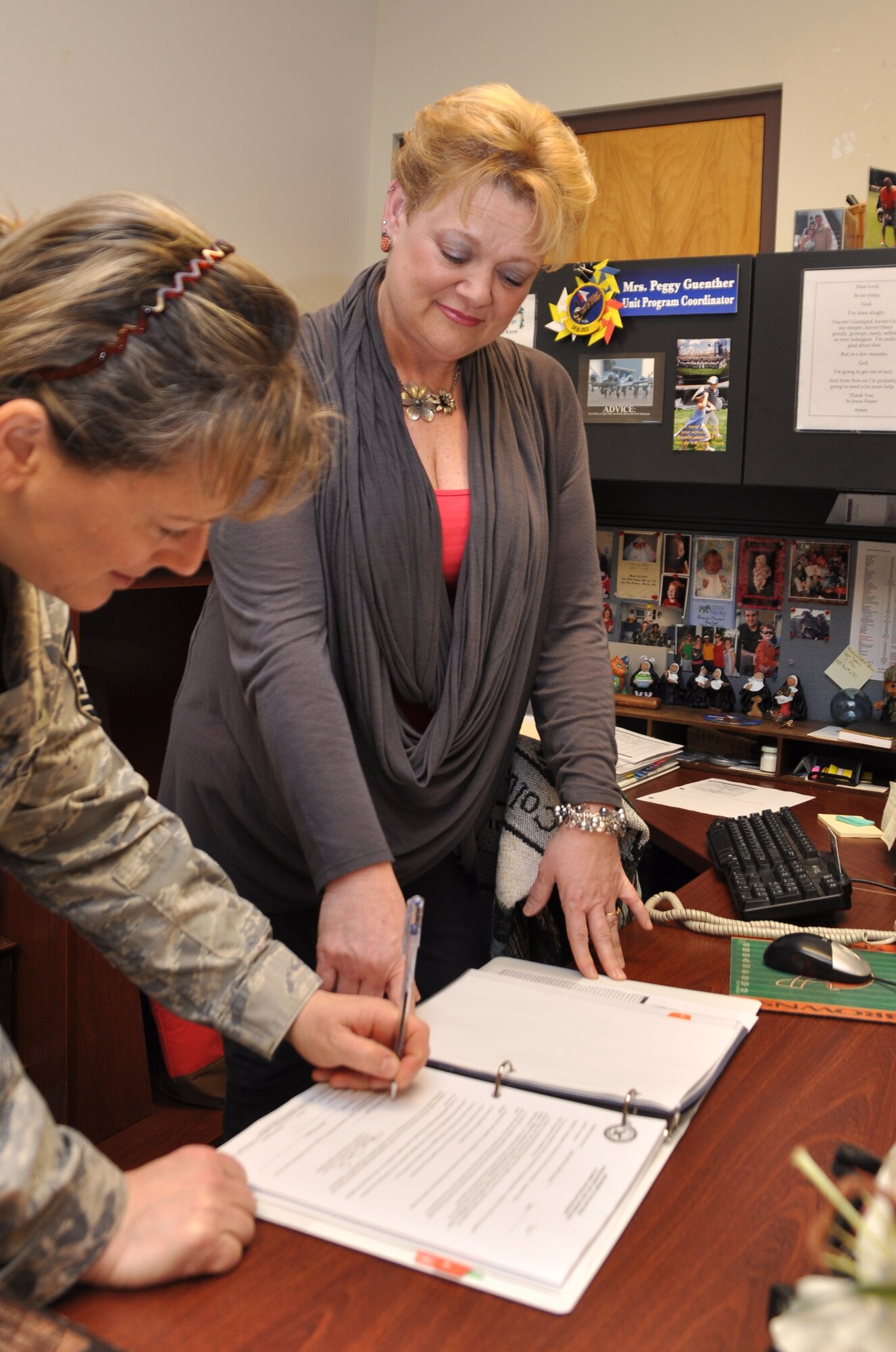 Peggy Guenther, 14th Operations Support Squadron Unit Program Coordinator, assists a member of her unit in filling out an application for a government driver's liscense. (U.S. Air Force photo/Airman 1st Class Chase Hedrick)