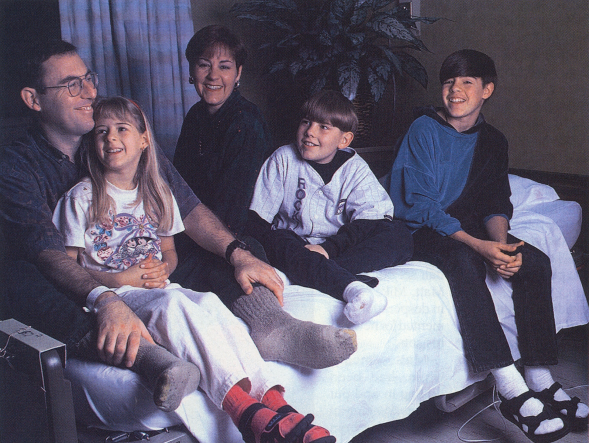 MIRACLE ON THE MOUNTAIN - Surrounded by his family at Wilford Hall Medical Center in San Antonio, Mike still couldn't wear shoes after doctors had operated on his frostbitten feet. The family shared a laugh, recalling how Turkish tabloids claimed Mike was an American spy who took pills to sustain himself and used his son, Matt (center), as a cover up. In another instance, a prank caller claiming to be with freedom fighters said he had kidnapped the pair: "You know things are bad when you would actually be relieved to find out your husband and son are in the hands of terrorists," Mary said. "Because at least then you'd know they were alive." (Photo by Rose Reynolds)

