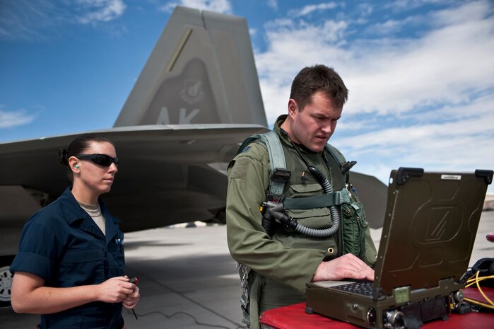 NELLIS AIR FORCE BASE, Nev. --  Senior Airman Samantha Whisman, 90th Aircraft Maintenance Squadron, crew chief, from Elmendorf Air Force Base, Alaska, looks on as  Capt. Drew Maulsby, 90th Fighter Squadron pilot, goes over electronic forms  before  departing on a training mission in a F-22 Raptor during Red Flag 11-3, March 2.  Red Flag is a realistic combat training exercise involving the air forces of the United States and its allies. The exercise takes place north of Las Vegas on the Nevada Test and Training Range--the U.S. Air Force's premier military training area with more than 12,000 square miles of airspace and 2.9 million acres of land. (U.S. Air Force photo by Tech Sgt. Michael R. Holzworth)