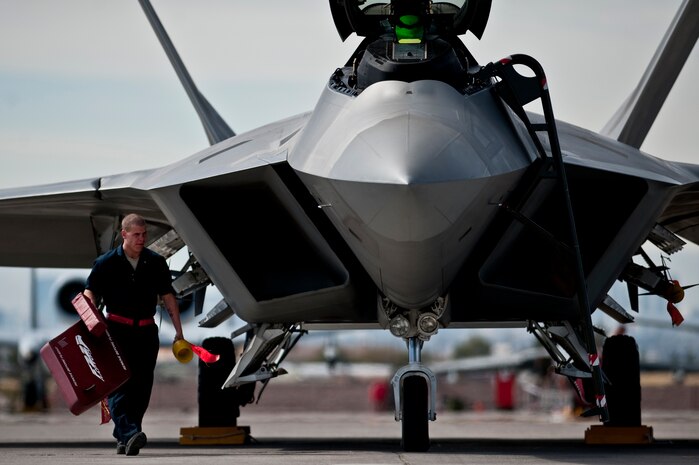 NELLIS AIR FORCE BASE, Nev. --  Airman 1st Class Jonathan Foster, 49th Aircraft Maintenance Squadron, crew chief, from Holloman Air Force Base, N.M. removes the intake covers of an F-22 Raptor before a training mission during Red Flag 11-3, March 2.  Red Flag is a realistic combat training exercise involving the air forces of the United States and its allies. The exercise takes place north of Las Vegas on the Nevada Test and Training Range--the U.S. Air Force's premier military training area with more than 12,000 square miles of airspace and 2.9 million acres of land. (U.S. Air Force photo by Tech Sgt. Michael R. Holzworth)