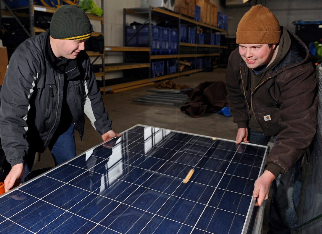 (Left) James Kliewer and Jonathan Rexroad, 28th Civil Engineer Squadron engineering technicians, handle one of 162 photovoltaic solar panels to be used in an energy conservation project on Ellsworth Air Force Base, S.D., Feb. 24, 2011.  The pair are two of the four Student Temporary Employment Program participant working in the 28th CES Asset Management Flight. (U.S. Air Force photo/Staff Sgt. Marc I. Lane)