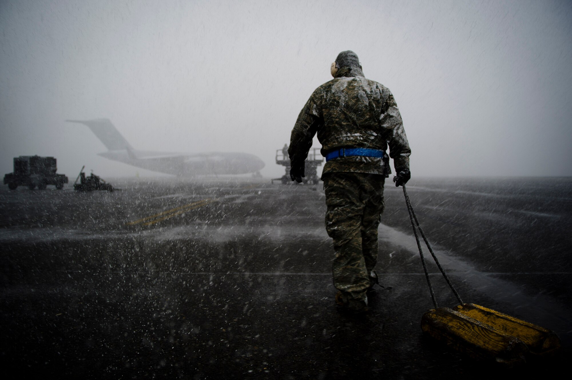 An Airman assigned the 62nd Aircraft Maintenance Squadron pulls a set of wheel chocks toward a C-17 Globemaster III Feb. 23, 2011, at McChord Air Force Base, Wash. (U.S. Air Force photo /Staff Sgt. Michael B. Keller)
