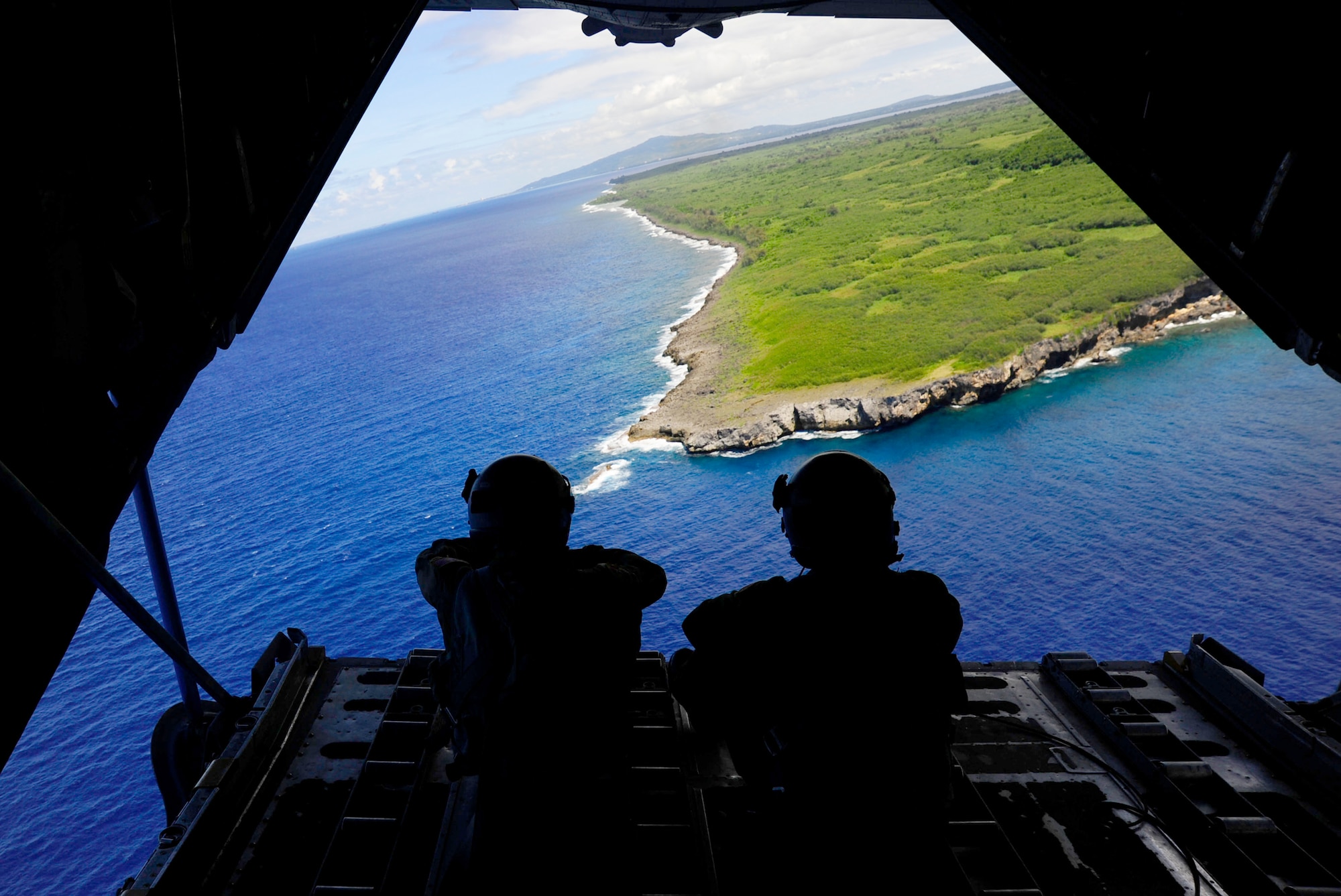 Staff Sgt. Keo Khamonel and Staff Sgt. Stewart Guethlein admire the view from the back of a C-130 Hercules Feb. 23, 2011, over Tumon Bay, near Guam, during exercise Cope North. Sergeants Guthlein and Khamonel are loadmasters from the 36th Airlift Squadron at Yokota Air Base, Japan. (U.S. Air Force photo/Staff Sgt. Angelita M. Lawrence)

