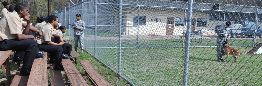 Navy Junior Reserve Officer Training Corps cadets from Neville High School watch a K-9 working dog demonstration conducted by the 2nd Security Forces Squadron Military Working Dog handlers at the 2 SFS Military Working Dog kennel on Barksdale Air Force Base, La., March 2. The kennel was the first stop for the cadets on their tour of the base. Neville High School is located in Monroe, La.(U.S. Air Force photo/Airman 1st Class Micaiah Anthony)(RELEASED)