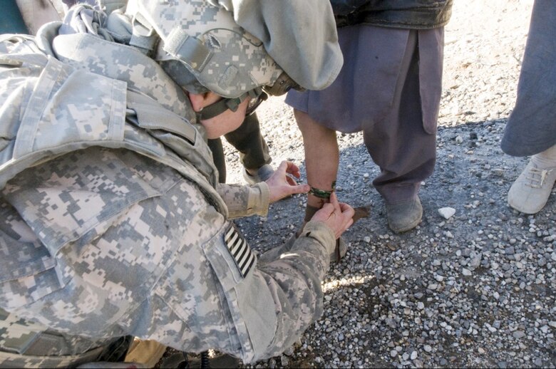 Capt. Ann Voght applies a bandage to an Afghan boy during a patrol in Afghanistan. Captain Voght is a medical officer assigned to Provincial Reconstruction Team Kapisa. (U.S. Air Force photo/Staff Sgt. Kyle Brasier)
