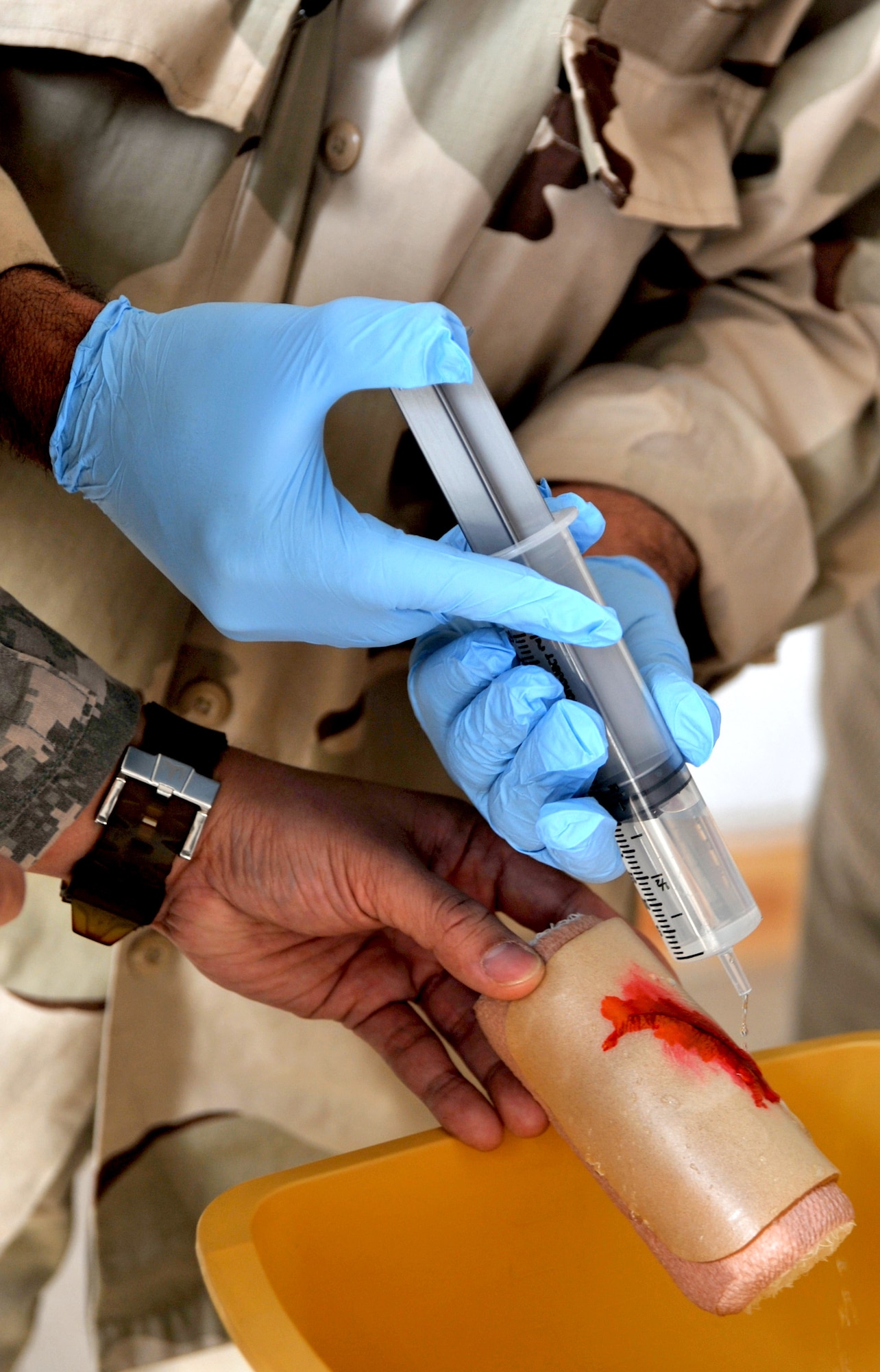 An Iraqi airman washes dirt out of an artificial laceration during a medical training course Feb. 23, 2011, at the medical clinic on Ali Air Base, Iraq. Airmen assigned to the base transition team here have helped improve the clinic’s ability to meet the needs of the Iraqi Air Force by providing $200,000 in essential medical equipment, increasing storage capacity and coordinating monthly self-aid buddy care training. (U.S. Air Force photo by Senior Airman Andrew Lee/Released)
