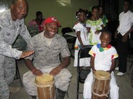 Staff Sgt Kevin Keith, (middle) a heavy equipment journeyman with the 567th RED HORSE, along with Master Sgt. Bennie Baker, security forces, plays the drums with local Meteti children while on deployment for New Horizons 2010. Panamanians performed locally influenced shows before U.S. military departures.(USAF photo courtesy of the 567RHS)
