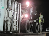Tech. Sgt. Clifford Walton, a structural craftsman, spots Tech. Sgt. Bobby Moore, a power pro craftsman, as he stages a container of tent building material while deployed as part of New Horizons 2010. Both Airmen are reservists with the 567th RED HORSE Squadron. (USAF photo courtesy of the 567RHS)
