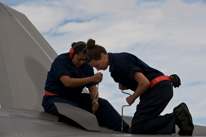 NELLIS AIR FORCE BASE, Nev. --  Senior Airman Idma Ramirez and Senior Airman Sheila Smith, 90th Aircraft Maintenance Squadron crew chiefs, Elmendorf Air Force Base, Alaska, conduct maintenance on an F-22 Raptor during Red Flag 11-3, March 2. Red Flag is a realistic combat training exercise involving the air forces of the United States and its allies. The exercise is hosted north of Las Vegas on the Nevada Test and Training Range. (U.S. Air Force photo by Airman 1st Class Matthew Lancaster)