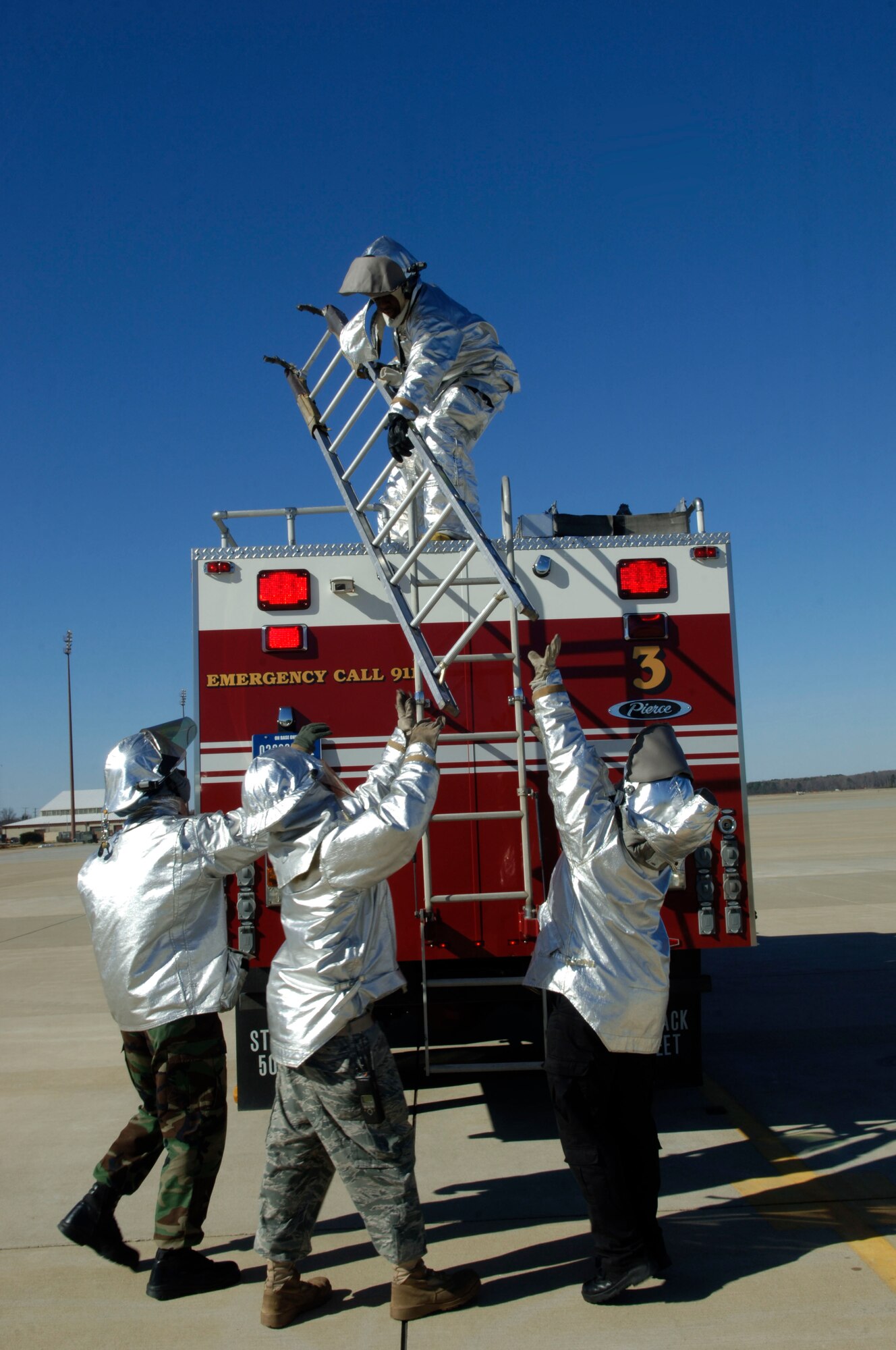 Members of the 633rd Civil Engineer Squadron Fire Department unload ladders during a T-38 Talon extraction training at Langley Air Force Base, Va., March 3, 2011. The T-38, from Holloman AFB, N.M., is being used in order to prepare the fire department for the arrival of the new aircraft at Langley. (U.S. Air Force photo by Airman 1st Class Racheal Watson/Released)