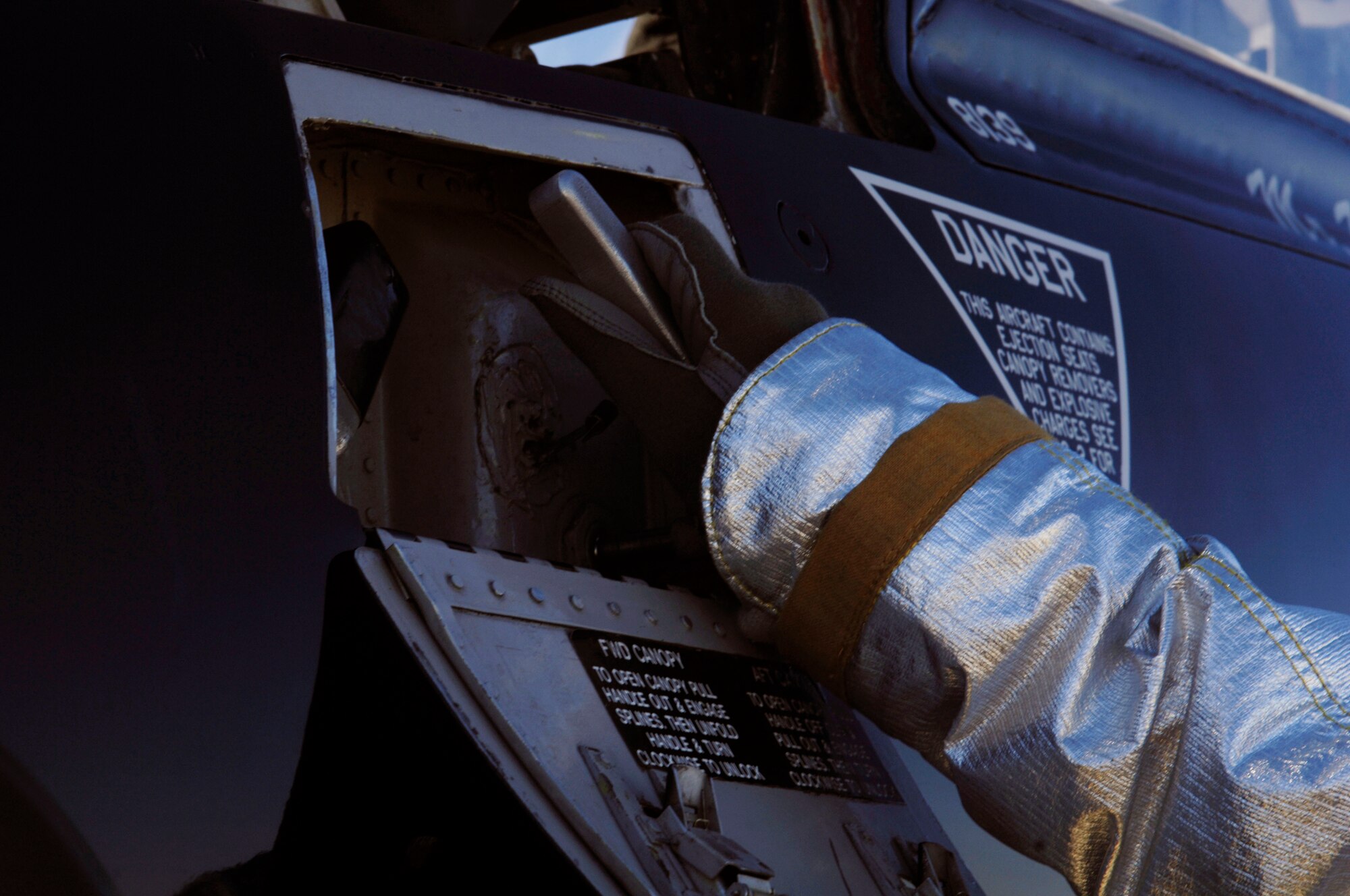 A member of the Langley Air Force Base Fire Department pulls on the canopy lever releasing the pilot during a T-38 Talon extraction training at Langley Air Force Base, Va., March 3, 2011. First responders have less than two minutes to evacuate the pilots from an aircraft during an emergency. (U.S. Air Force photo by Airman 1st Class Racheal Watson/Released)