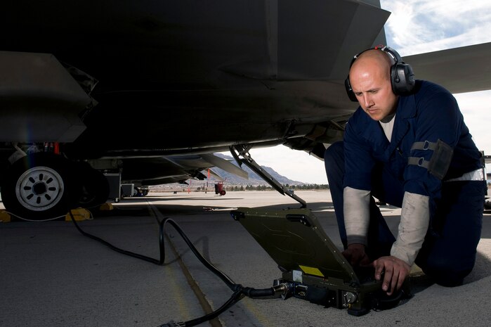NELLIS AIR FORCE BASE, Nev. --  Staff Sgt. Seth Miller, 3rd Aircraft Maintenance Squadron crew chief, Elmendorf Air Force Base, Alaska, performs pre-flight checks before a mission over the Nevada Test and Training Range during Red Flag 11-3, March 1.  Red Flag is a realistic combat training exercise involving the air forces of the United States and its allies. The exercise is hosted north of Las Vegas on the Nevada Test and Training Range.(U.S. Air Force photo by Senior Airman Brett Clashman)