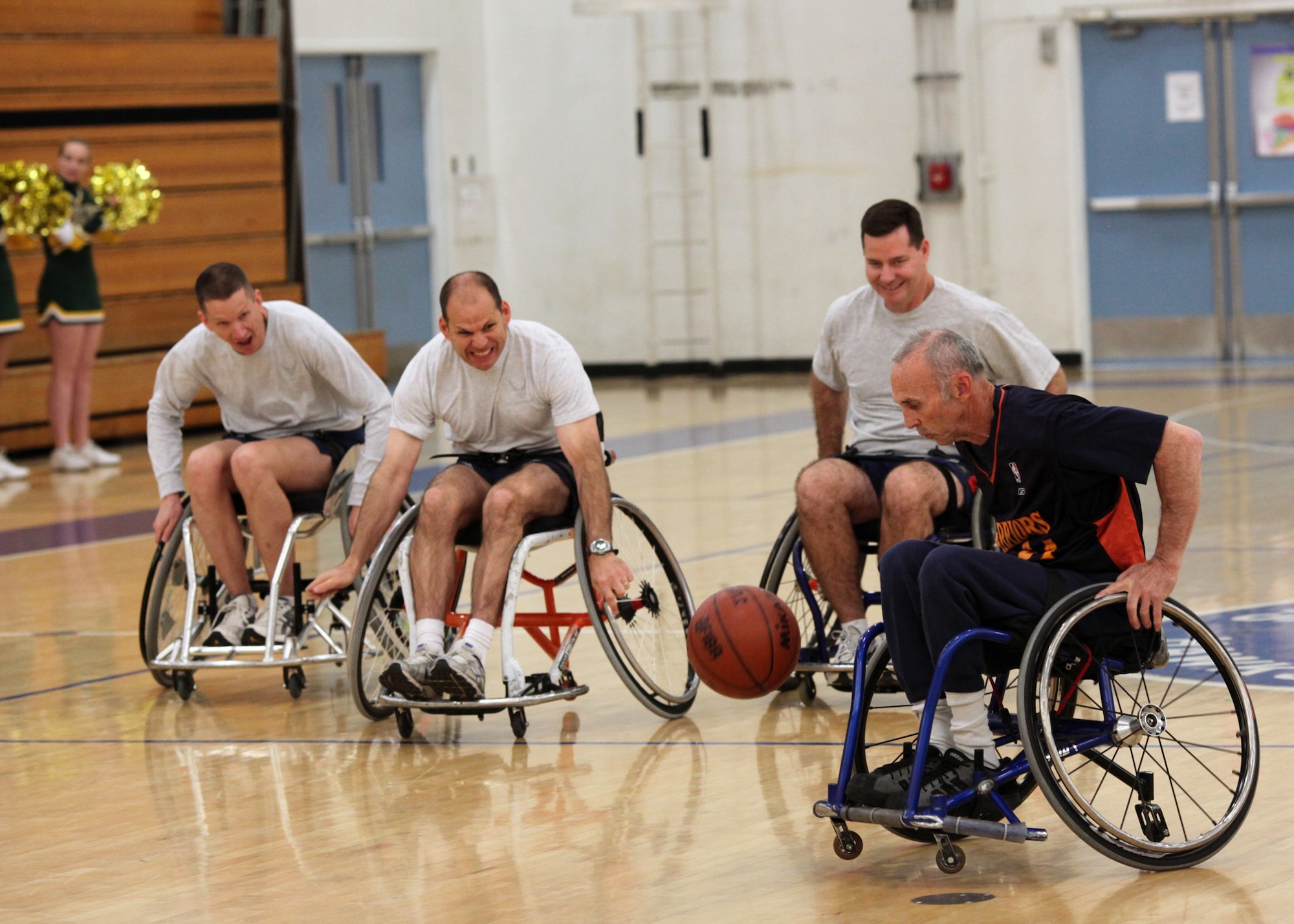 TRAVIS AIR FORCE BASE, Calif. -- Team Travis leadership faces off with the Golden State Road Warriors during a wheelchair basketball game at the Travis Fitness Center, Feb. 26, 2011. From right to left:  Road Warrior #24 Mike Elix; Col. Gary Gottschall, 615th Contingency Response Wing commander, Col. Jim Vechery, 60th Air Mobility Wing Commander. The Road Warriors are one of the top wheelchair basketball teams in the country, and play as members of the National wheelchair Basketball Association.  
The Airmen received an hour of training in the wheelchairs and were spotted 20 points, but the Road Warriors quickly asserted their dominance on the court.  The friendly, but spirited game hosted by the USO was cheered on by more than 300 members of the Team Travis community.  (U.S. Air Force photo / Lt.Col. Robert Couse-Baker)