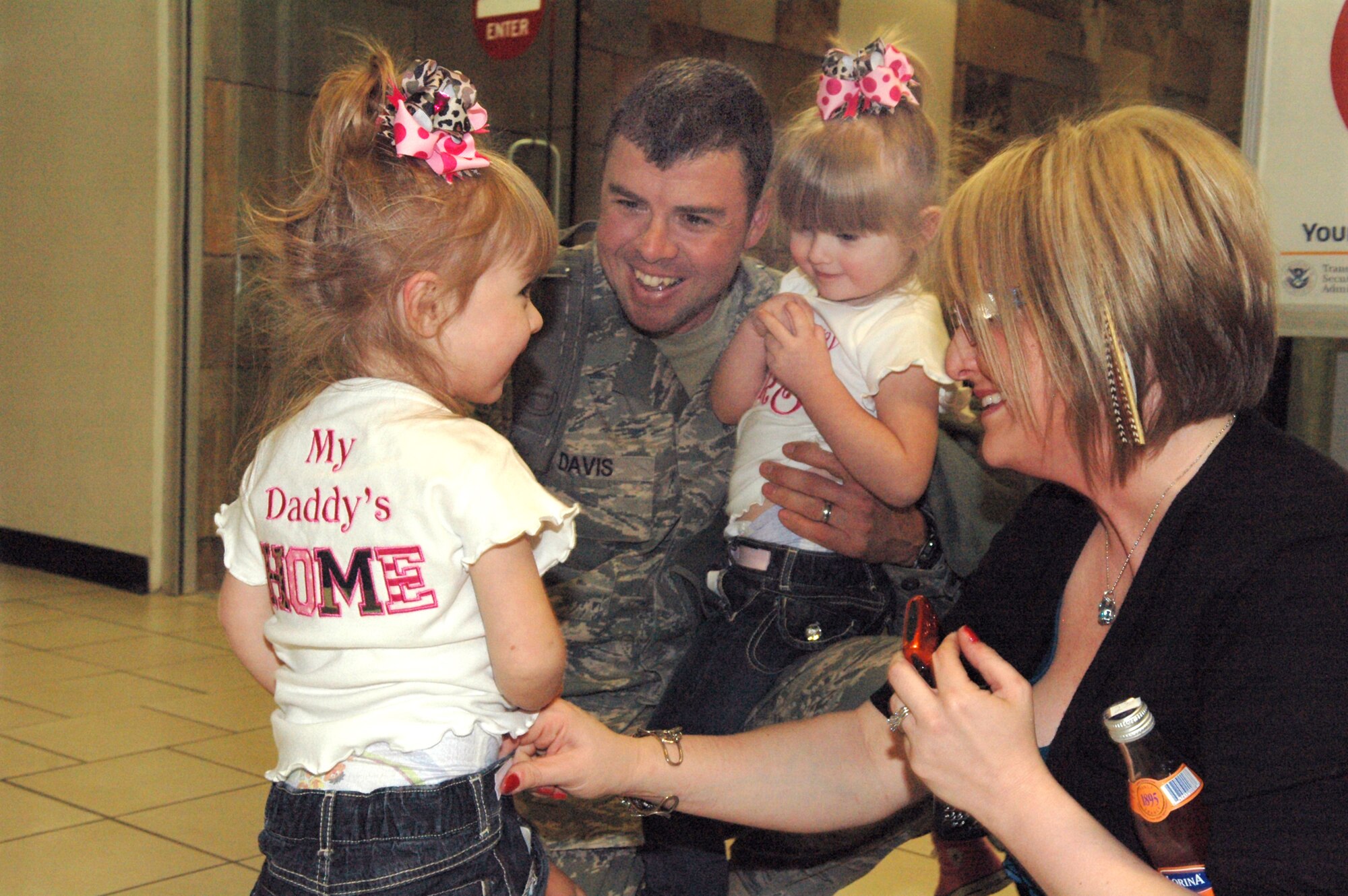 Tech. Sgt. Michael Davis, 72nd Security Forces Squadron, takes a special moment with his twin girls who leaped into his arms just moments before. Sergeant Davis and a 12-Airman security forces team returned after a six month deployment to Bagram Air Base, Afghanistan. They were greeted at Oklahoma City’s Will Rogers Airport security checkpoint by cheers and flashing cameras from family, friends and a long line of bystanders. (Air Force photo by Brion Ockenfels)
