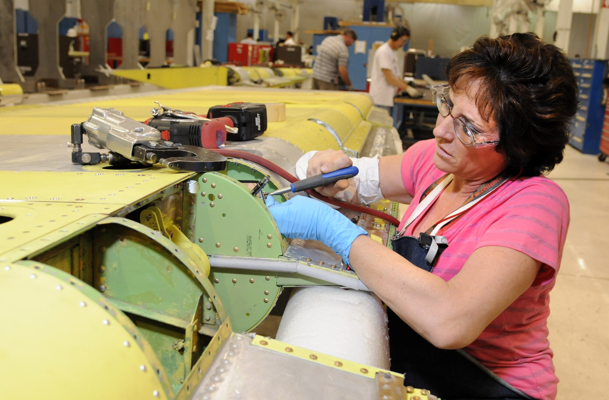 Linda Osborne, 551st CMMXS sheet metal mechanic, installs nut plates on a moon rib of a KC-135 rudder.  The KC-135 Rudder Shop is one of many production areas that the 551st CMMXS has implemented One-Piece Modular Flow Assembly Line improvements at Bldg. 9001. (Air Force photos by Dave Faytinger)