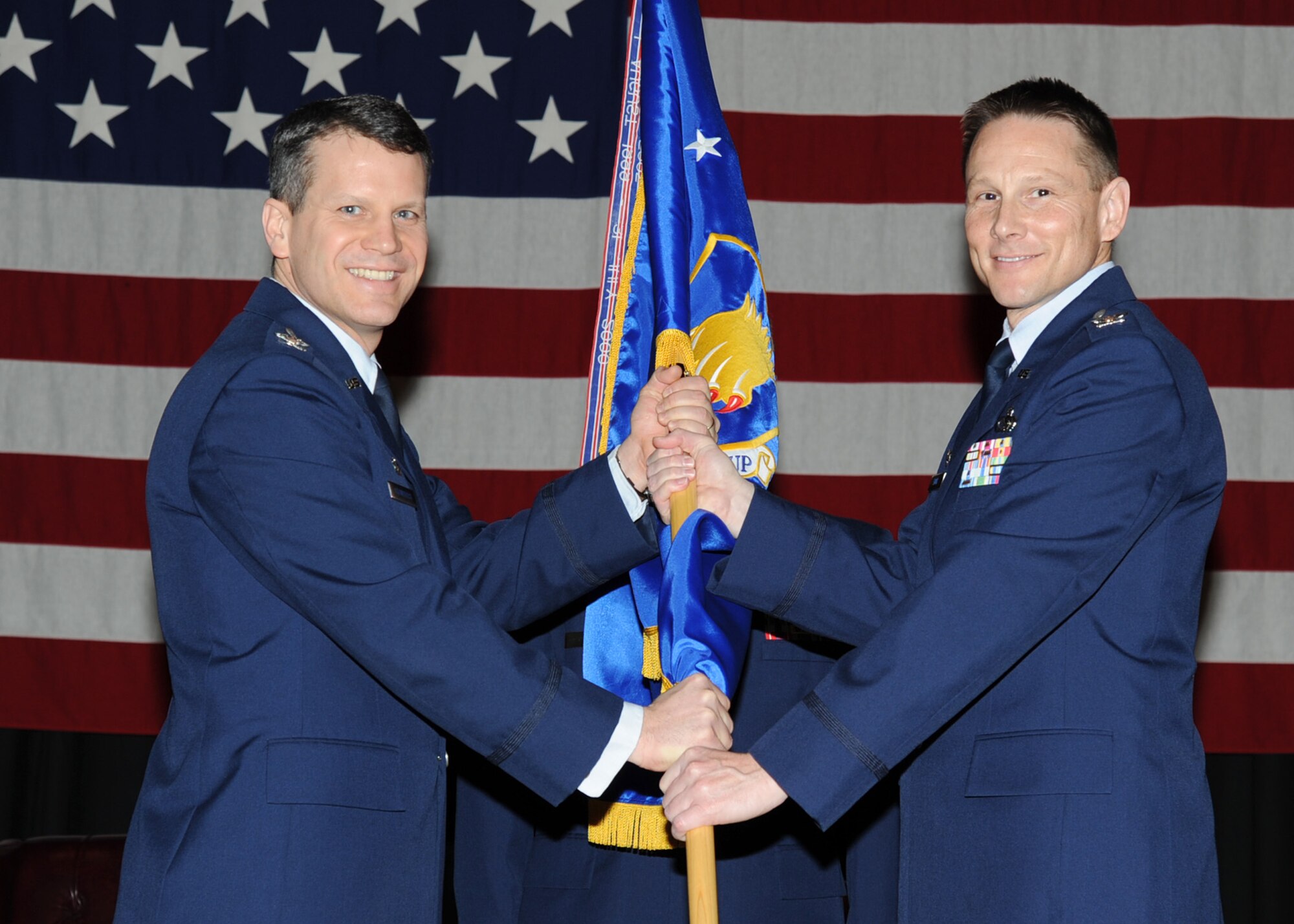 (Left to right) Col. Jamie Crowhurst, 22nd Air Refueling Wing commander, passes a guidon to Col. Mark Evans, 22nd Mission Support Group commander, during a change of command ceremony at the Robert J. Dole Community Center ballroom March 2, 2011, McConnell Air Force Base, Kan. The passing of the guidon symbolizes Colonel Evans’ assumption of command from the outgoing 22nd MSG commander, Col. Pat Rose. The 22nd MSG provides quality-of-life and installation support for the entire McConnell community.  (U.S. Air Force photo/Staff Sgt. Dallas Edwards)